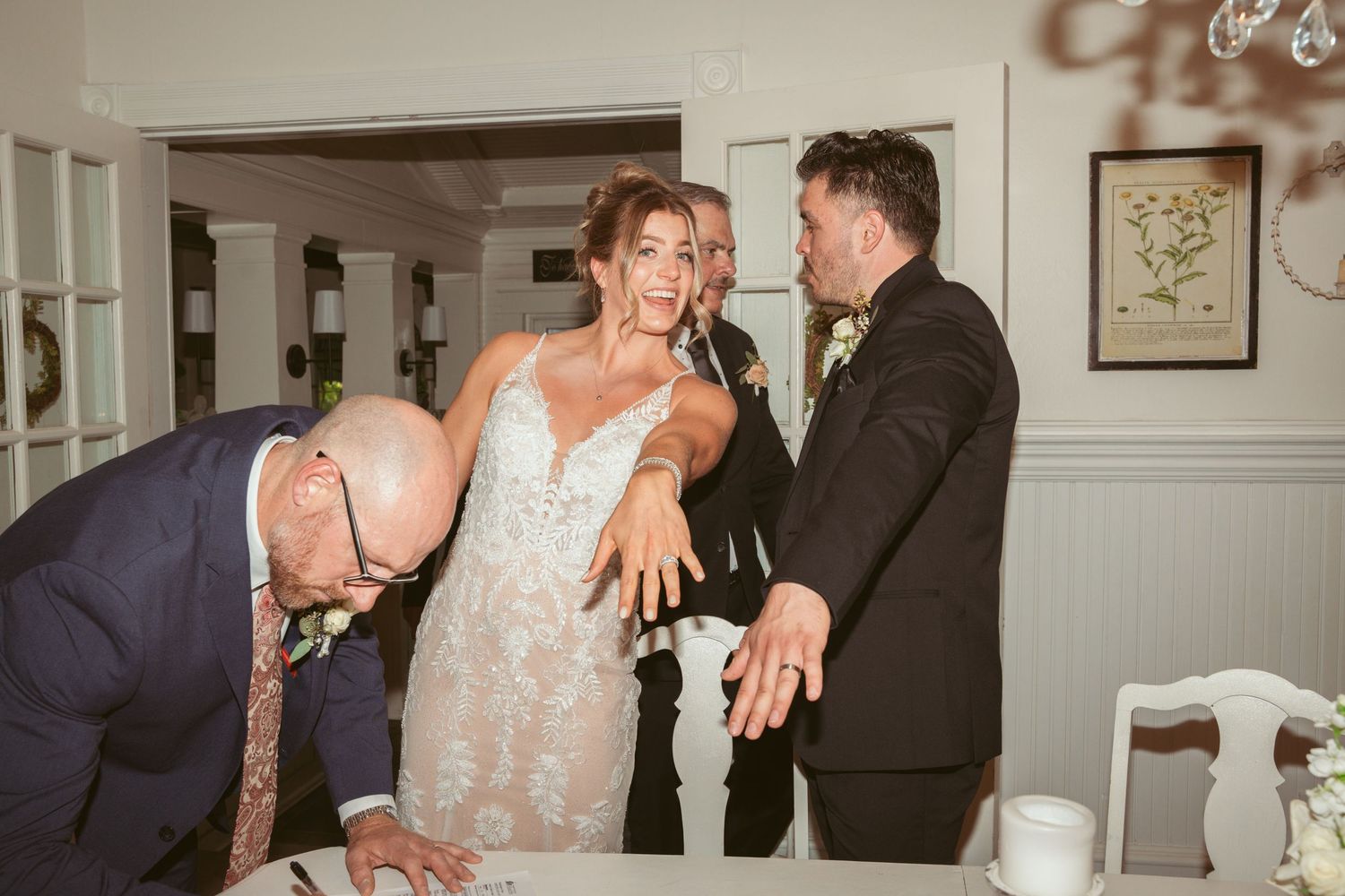 Wedding celebration with dancing and laughter inside a classically decorated room.