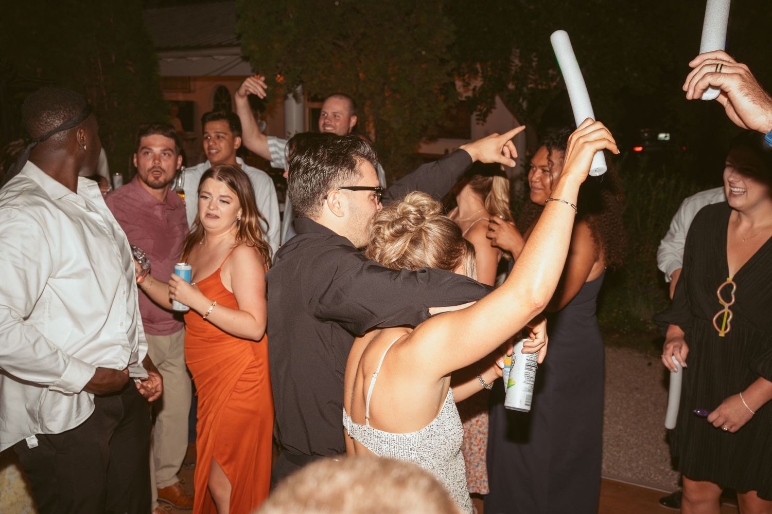 People dancing and enjoying themselves at an evening outdoor wedding reception.