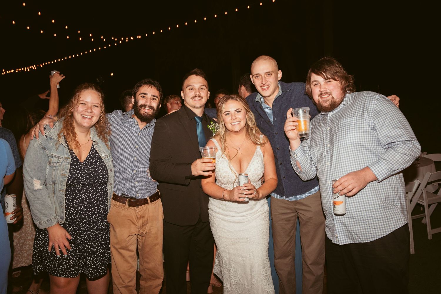 Party guests pose together for group photos at an outdoor evening celebration.