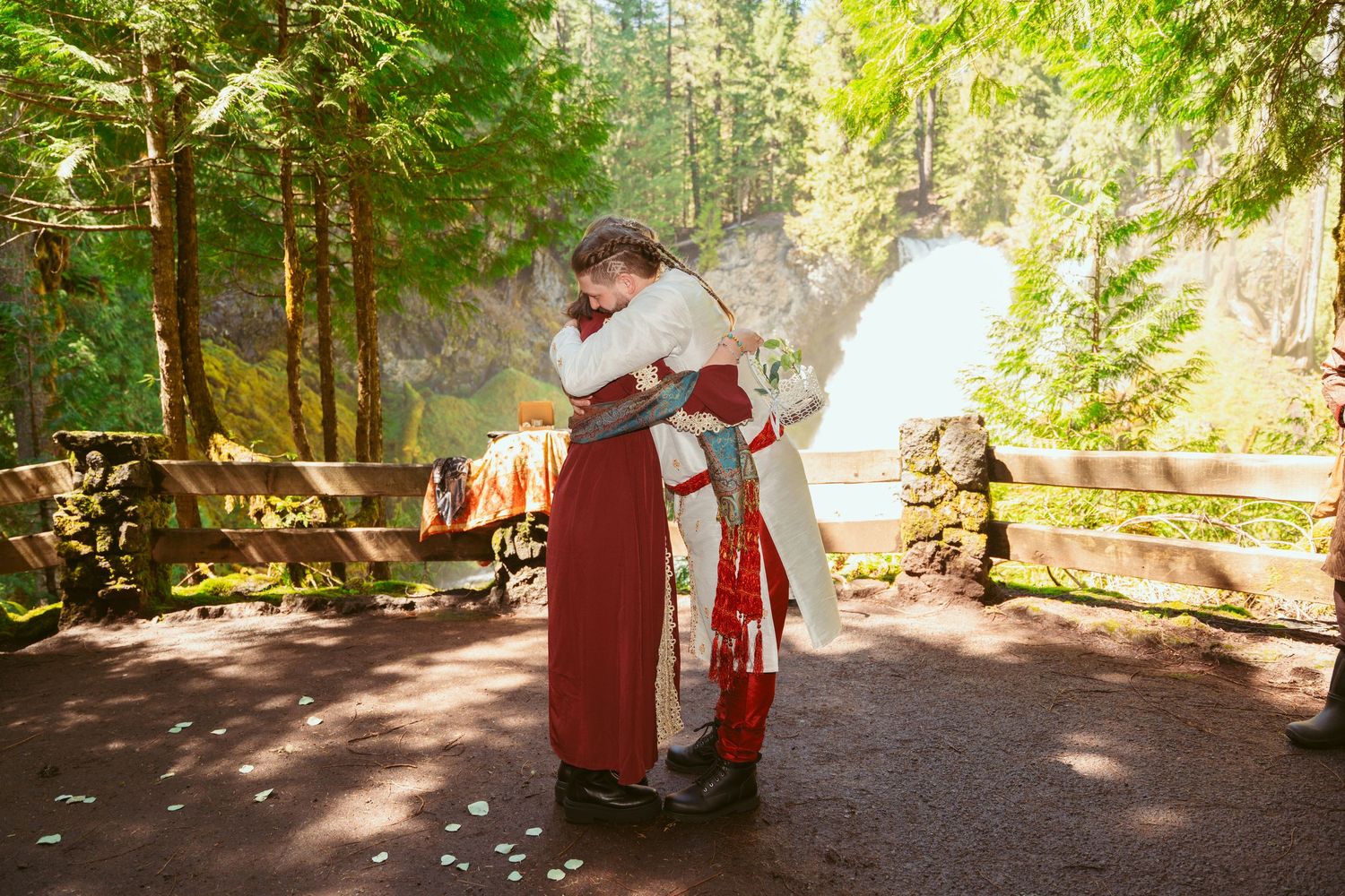 Medieval-themed wedding celebration with guests in period costumes gathered in a forest.