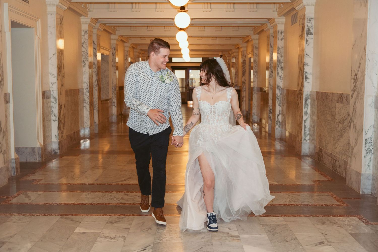Wedding couple sharing intimate moments in a long industrial hallway with columns.