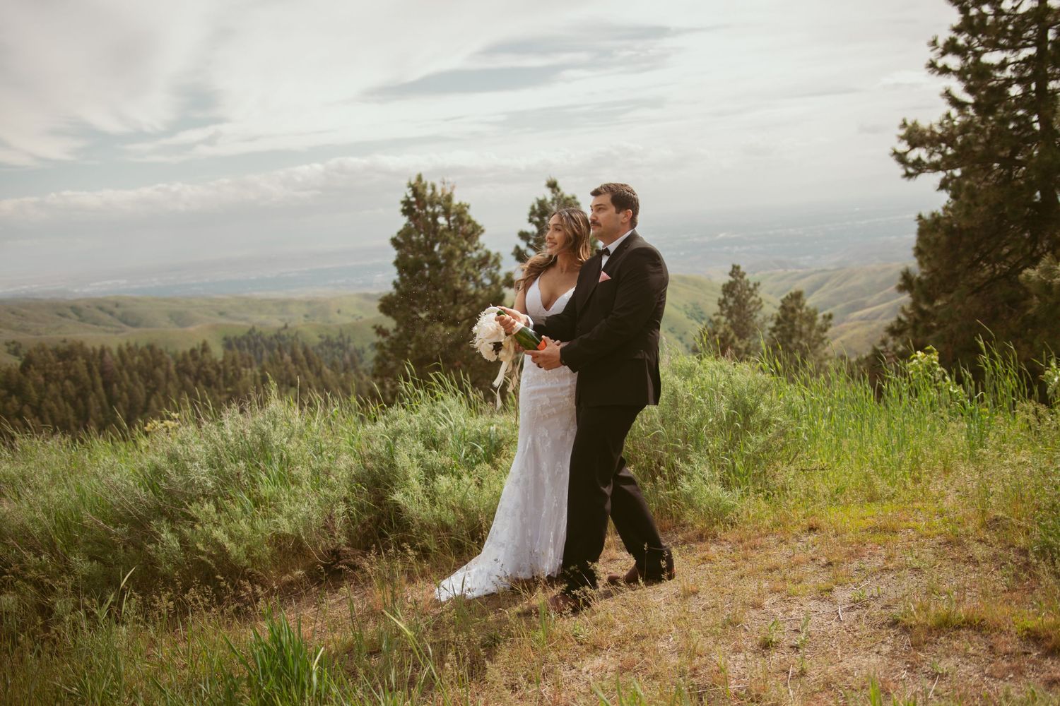 Couple sharing joyful moments during their mountaintop wedding celebration.