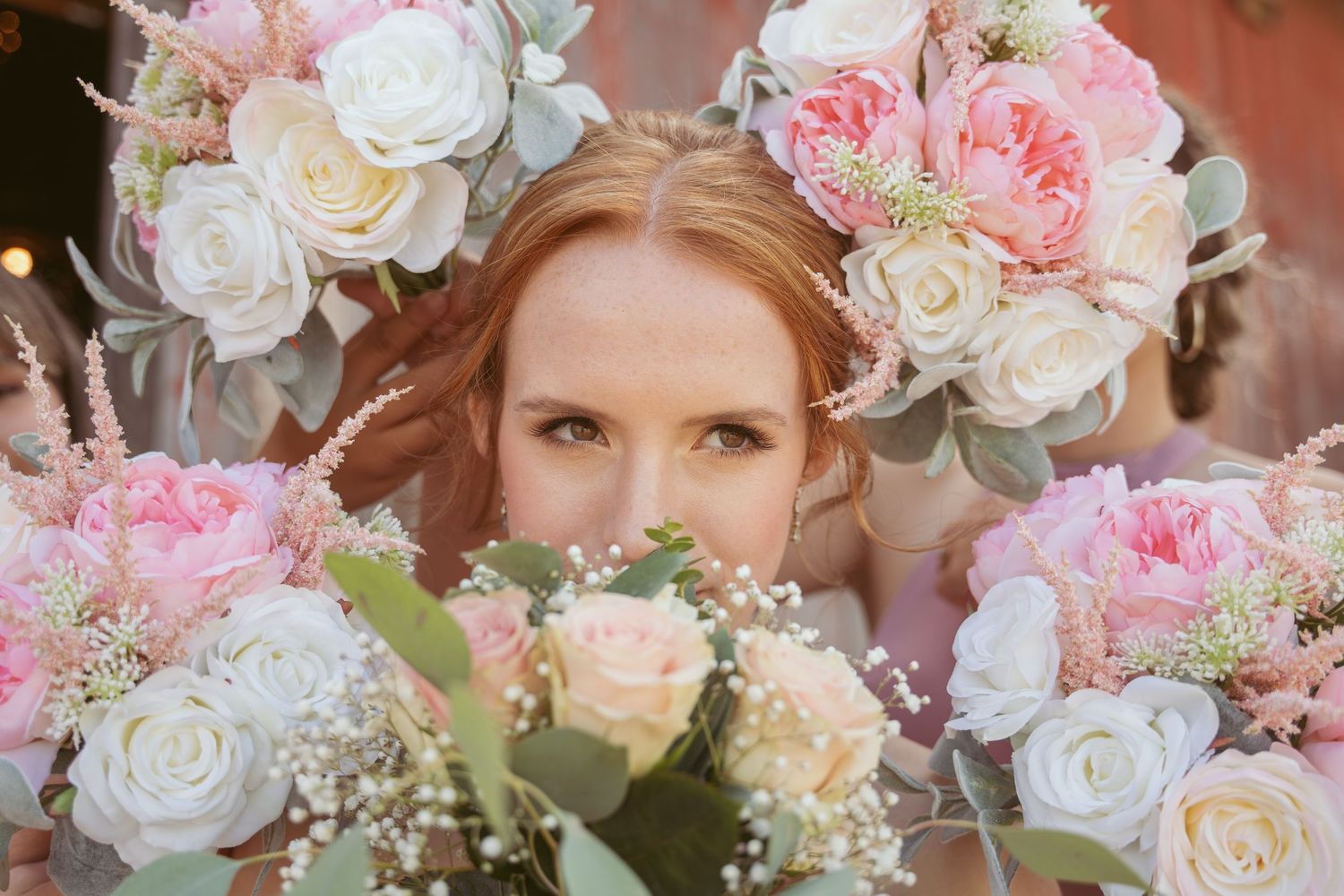 Romantic close-up of pink and white rose bouquets framing wedding day moment.