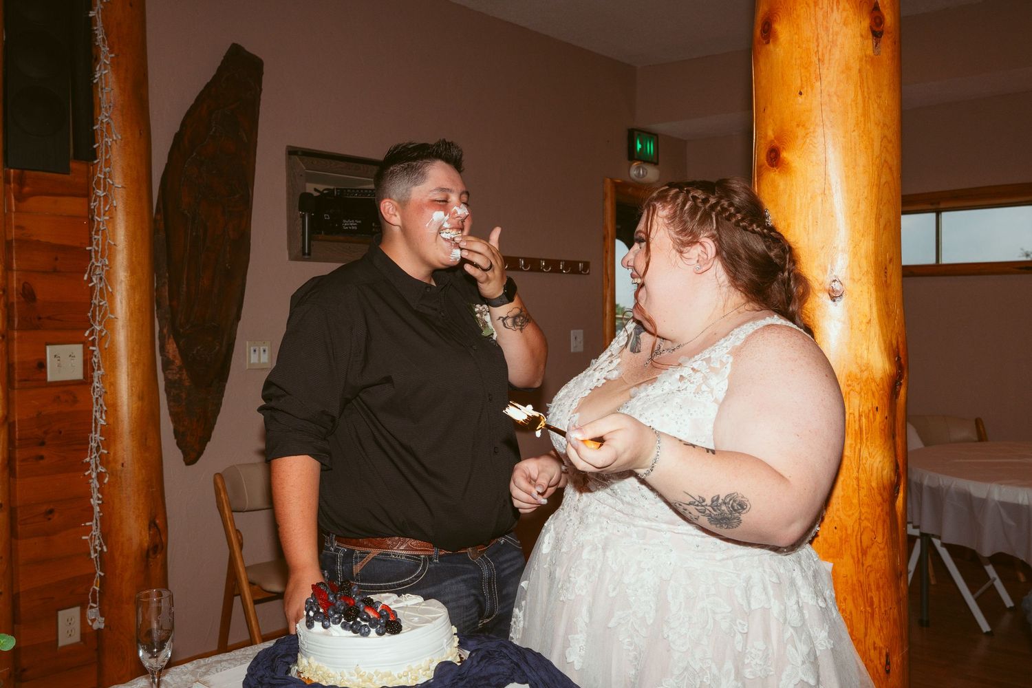 Wedding couple enjoying a fun cake-feeding moment at their reception.