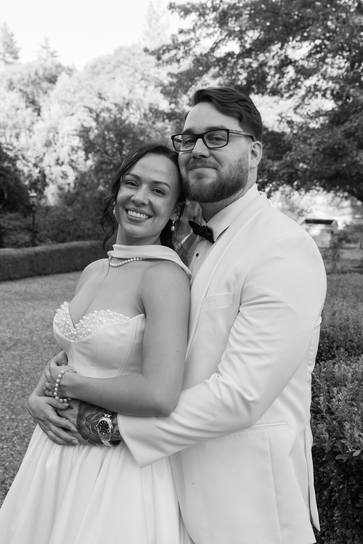 Candid wedding portraits showing joyful embraces and laughter in an outdoor garden setting.
