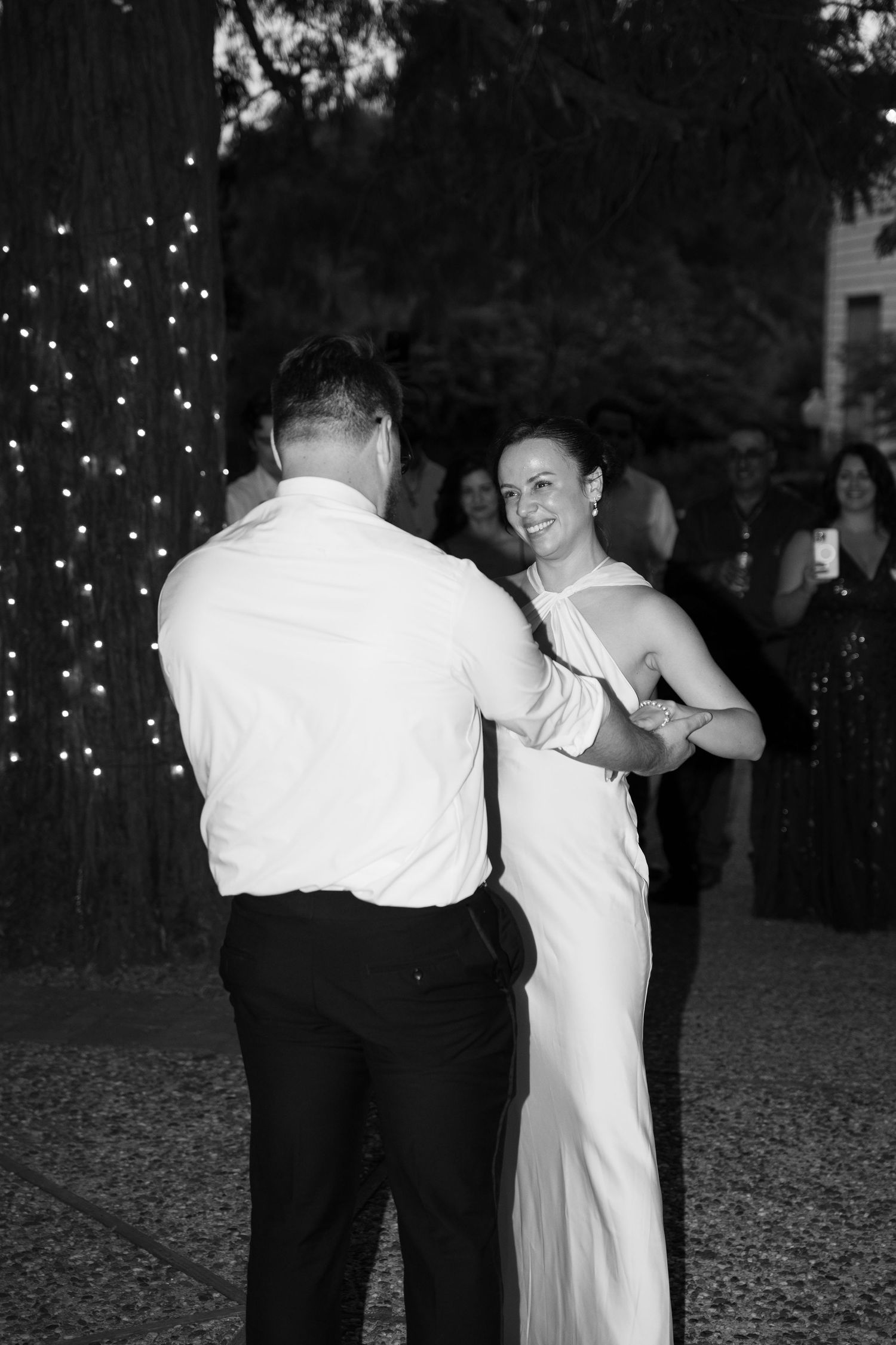 A couple shares an intimate dance moment at their outdoor wedding reception.