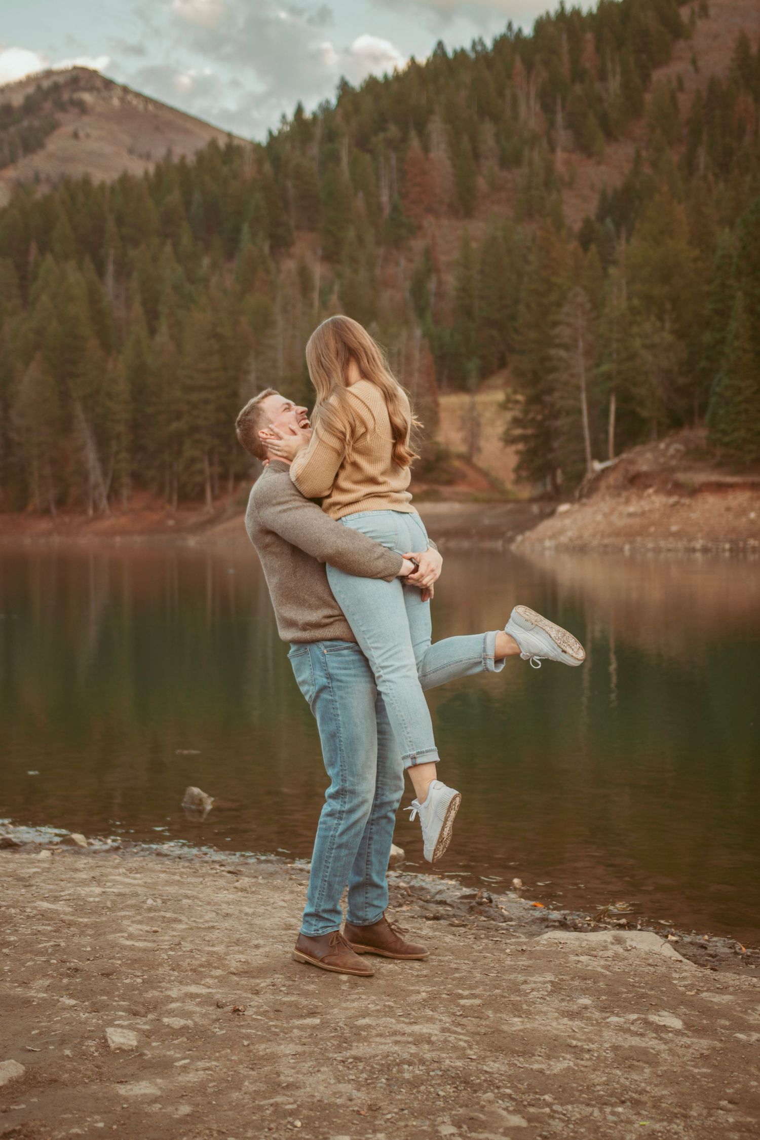 Joyful dancing and spinning captured against a serene mountain lake backdrop.