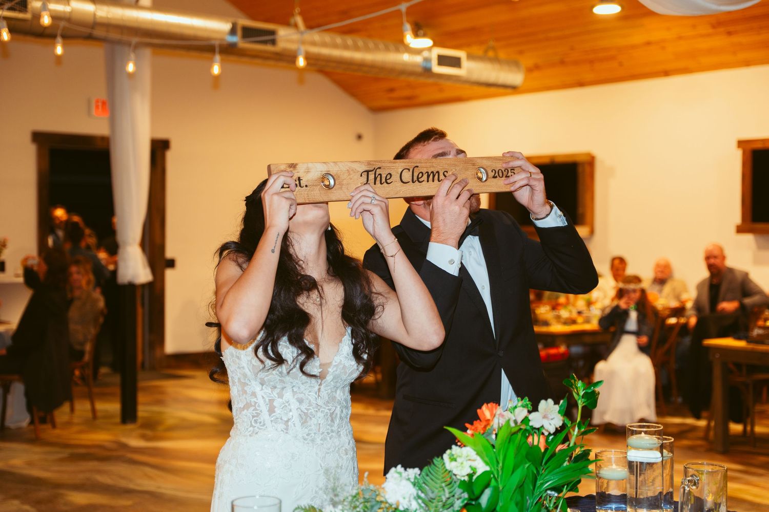 Wedding reception venue with wooden ceiling beams and string lights creating warm ambiance.