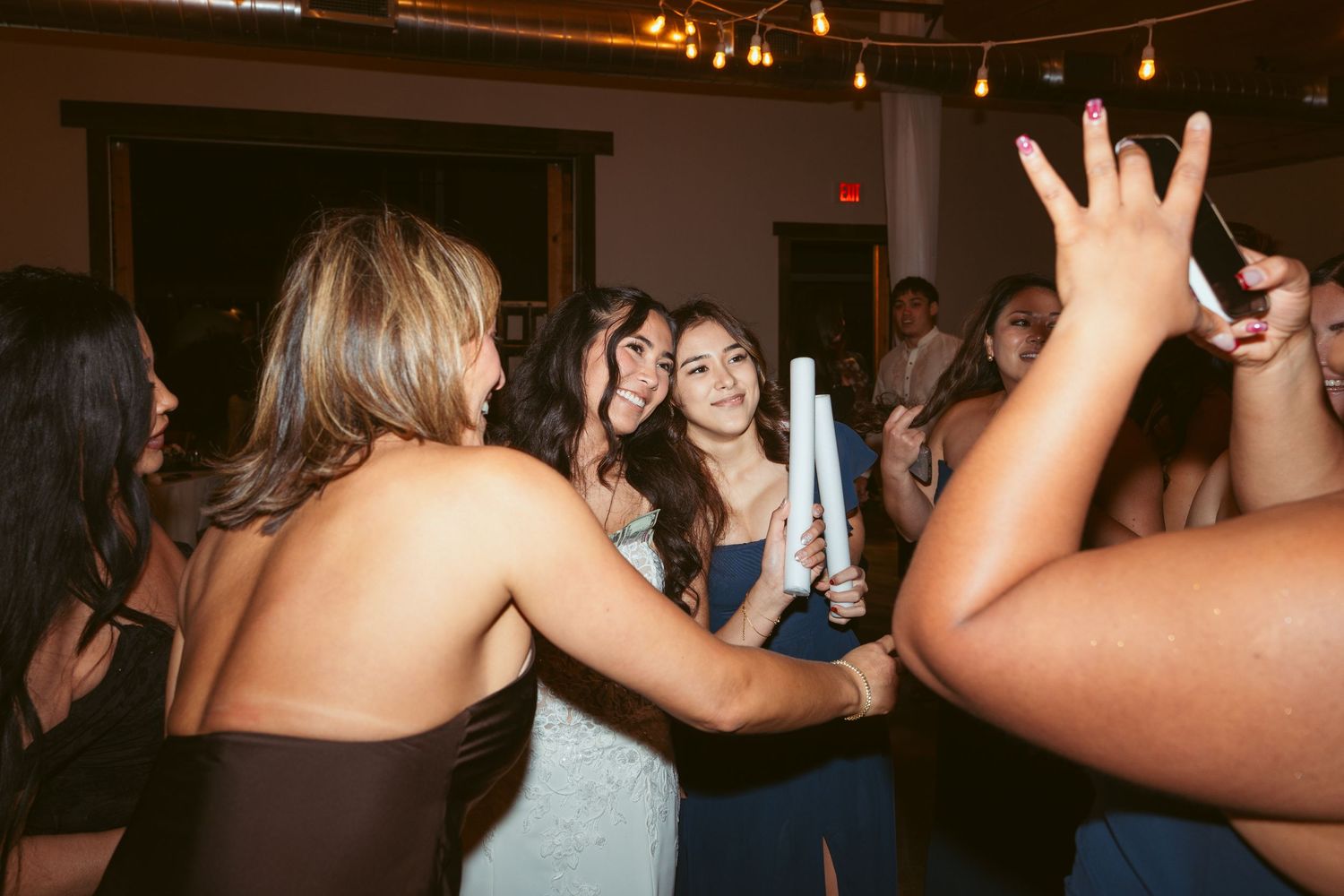 Wedding guests celebrating on the dance floor during an evening reception.