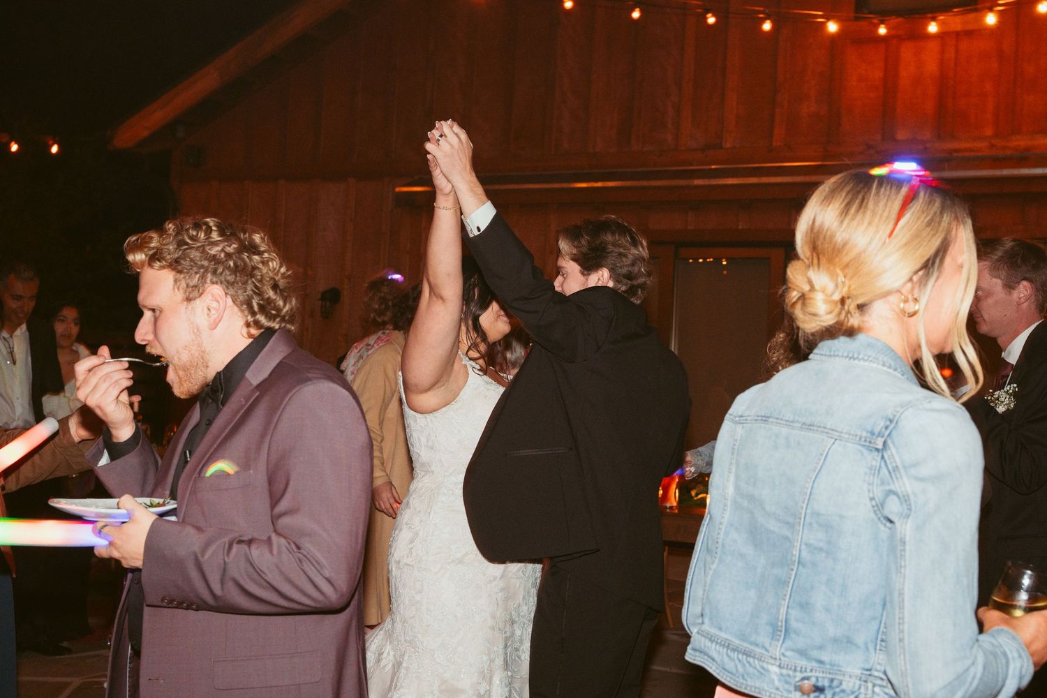Wedding reception dance party with string lights creating a festive nighttime atmosphere.