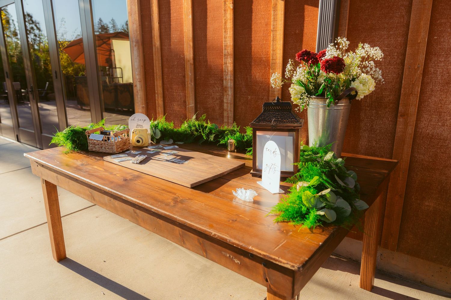 Wedding reception decor featuring wooden tables and benches in a rustic venue setting.