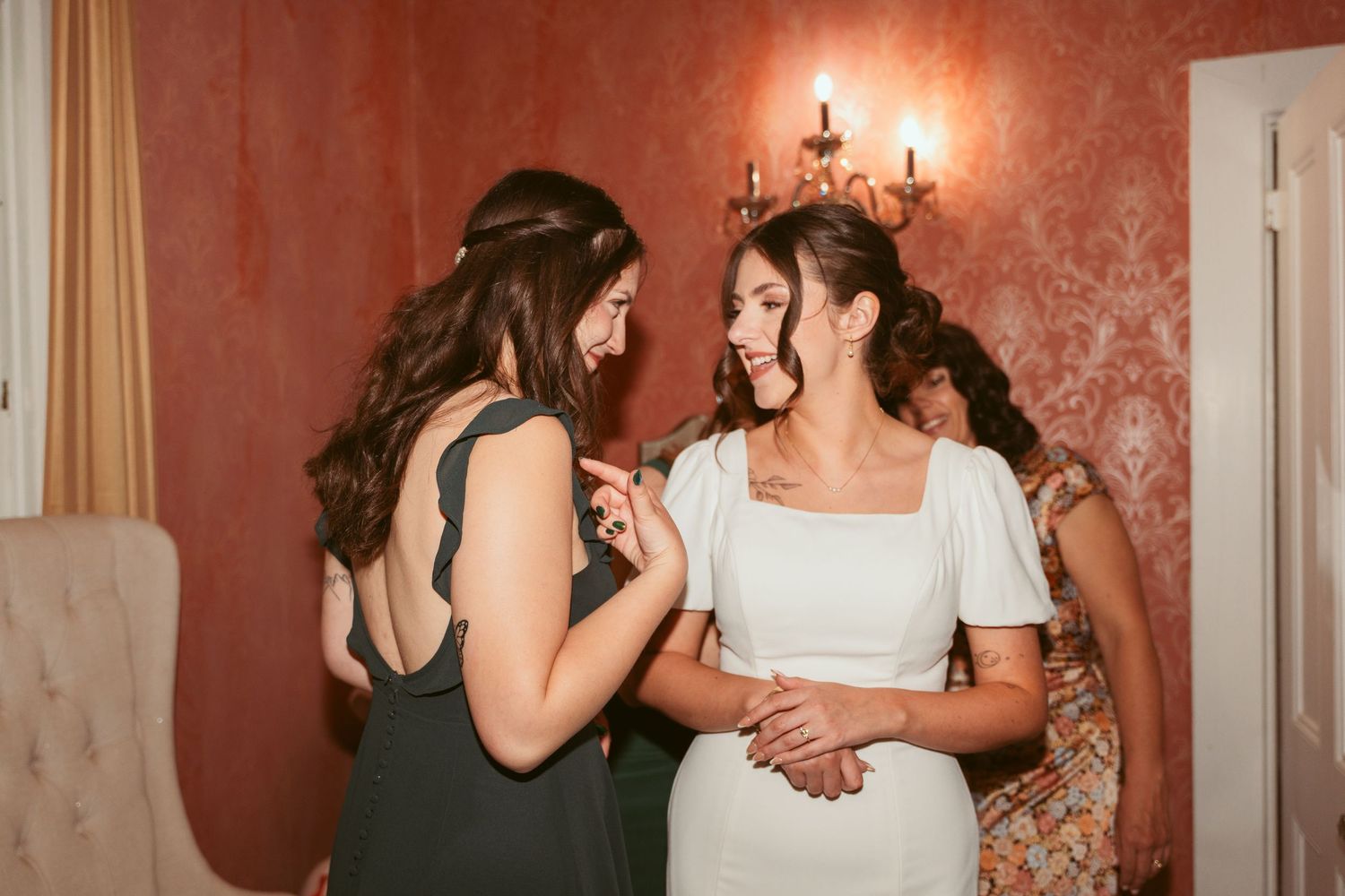 Wedding celebration candid moments in an elegant room with red walls.