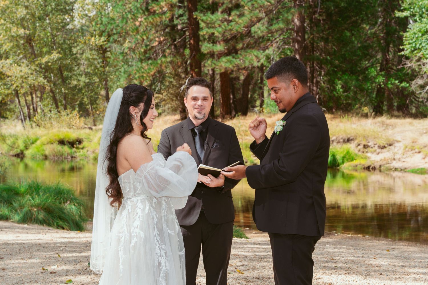 Intimate wedding ceremony taking place beside a river in Yosemite National Park.
