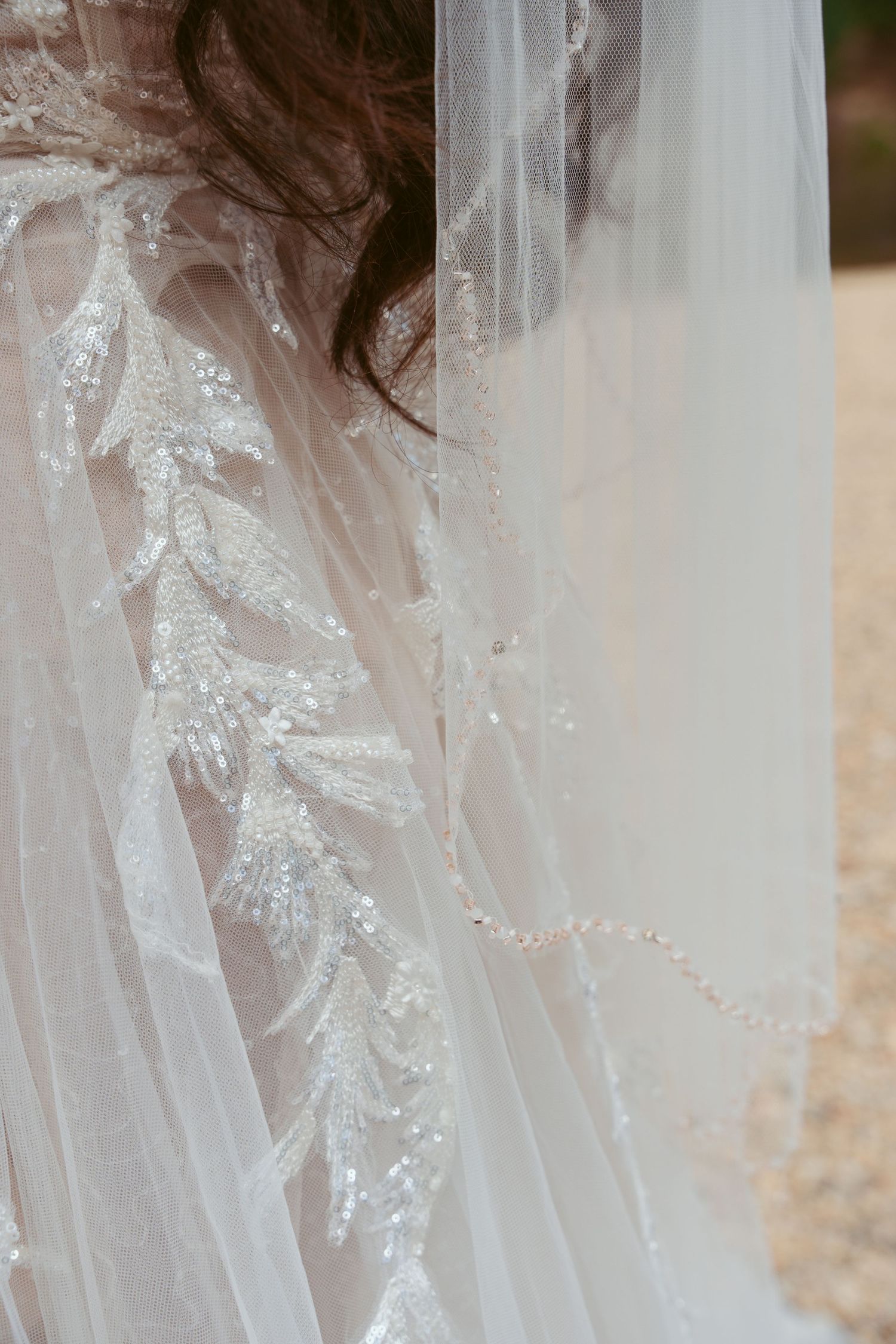 Intricate beaded lace detail on sheer white wedding veil.
