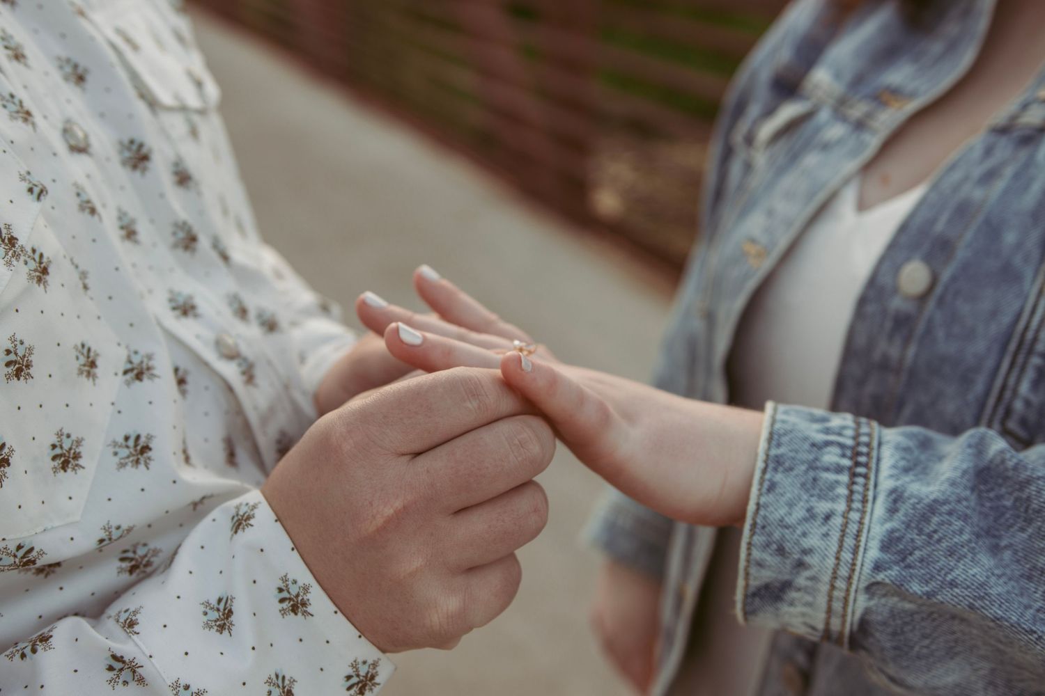 Close-up of hands making playful gestures against a light background.