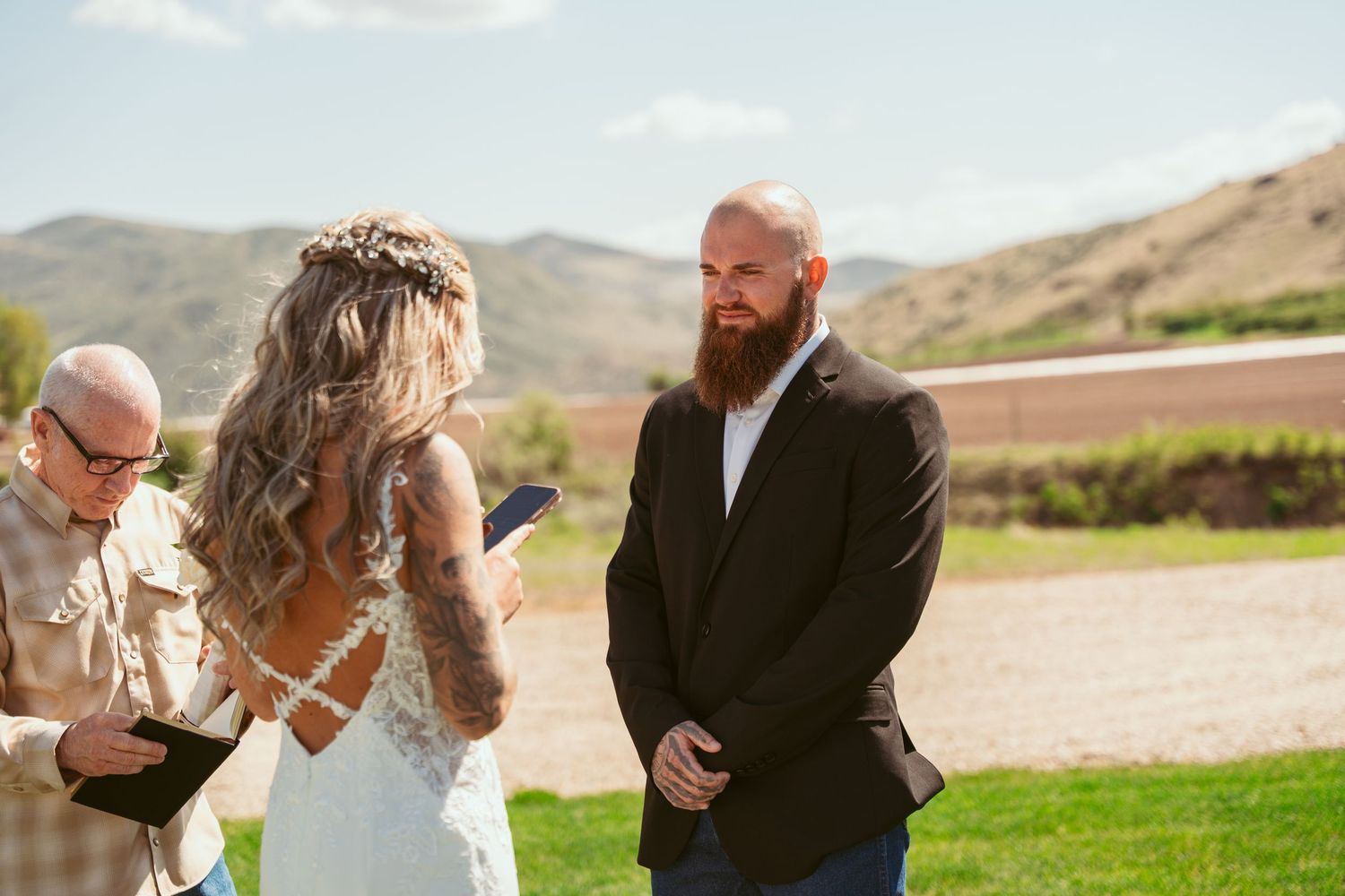 Intimate outdoor wedding ceremony with mountains in background.