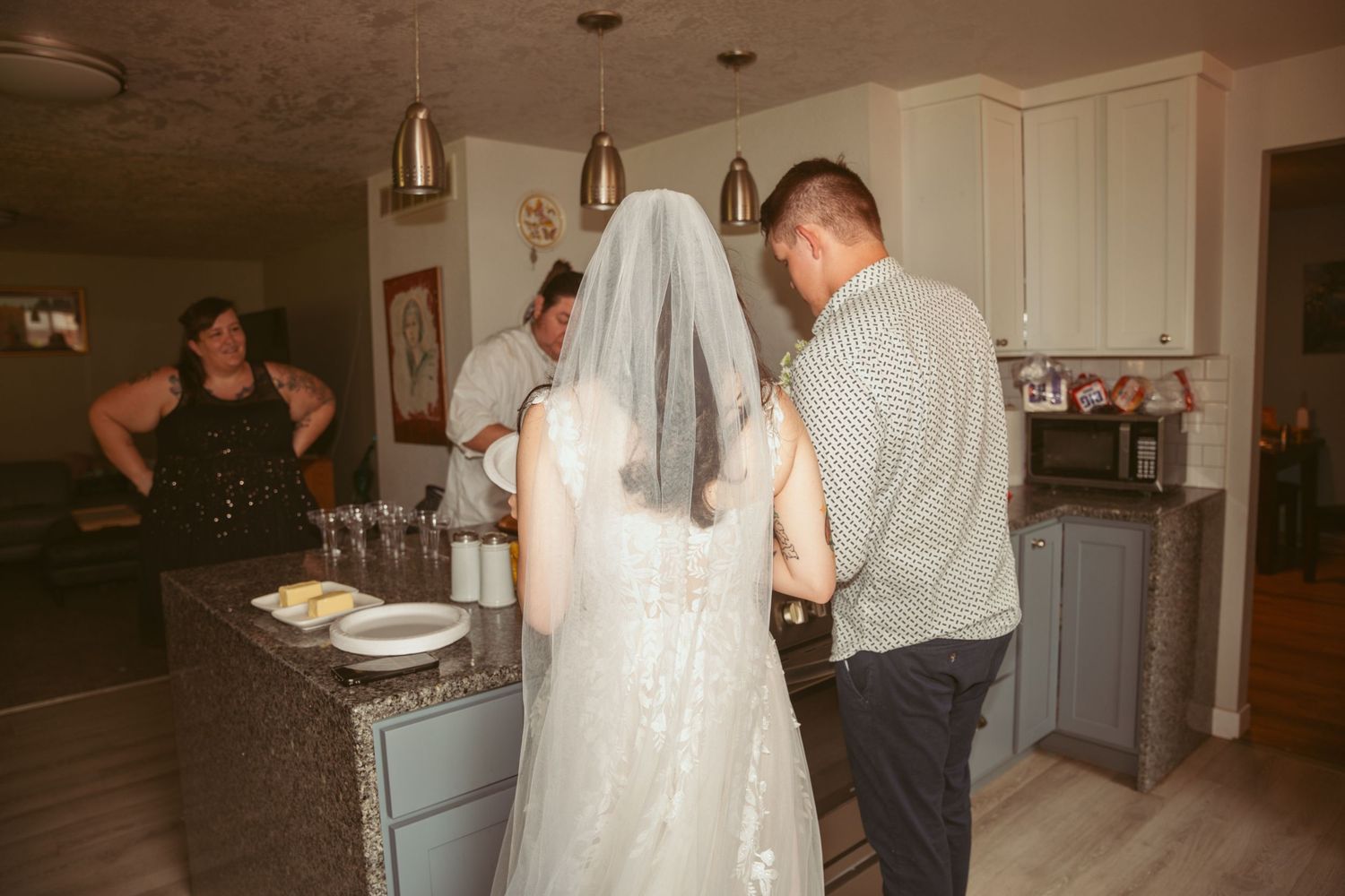 Wedding preparations taking place in modern kitchen setting.