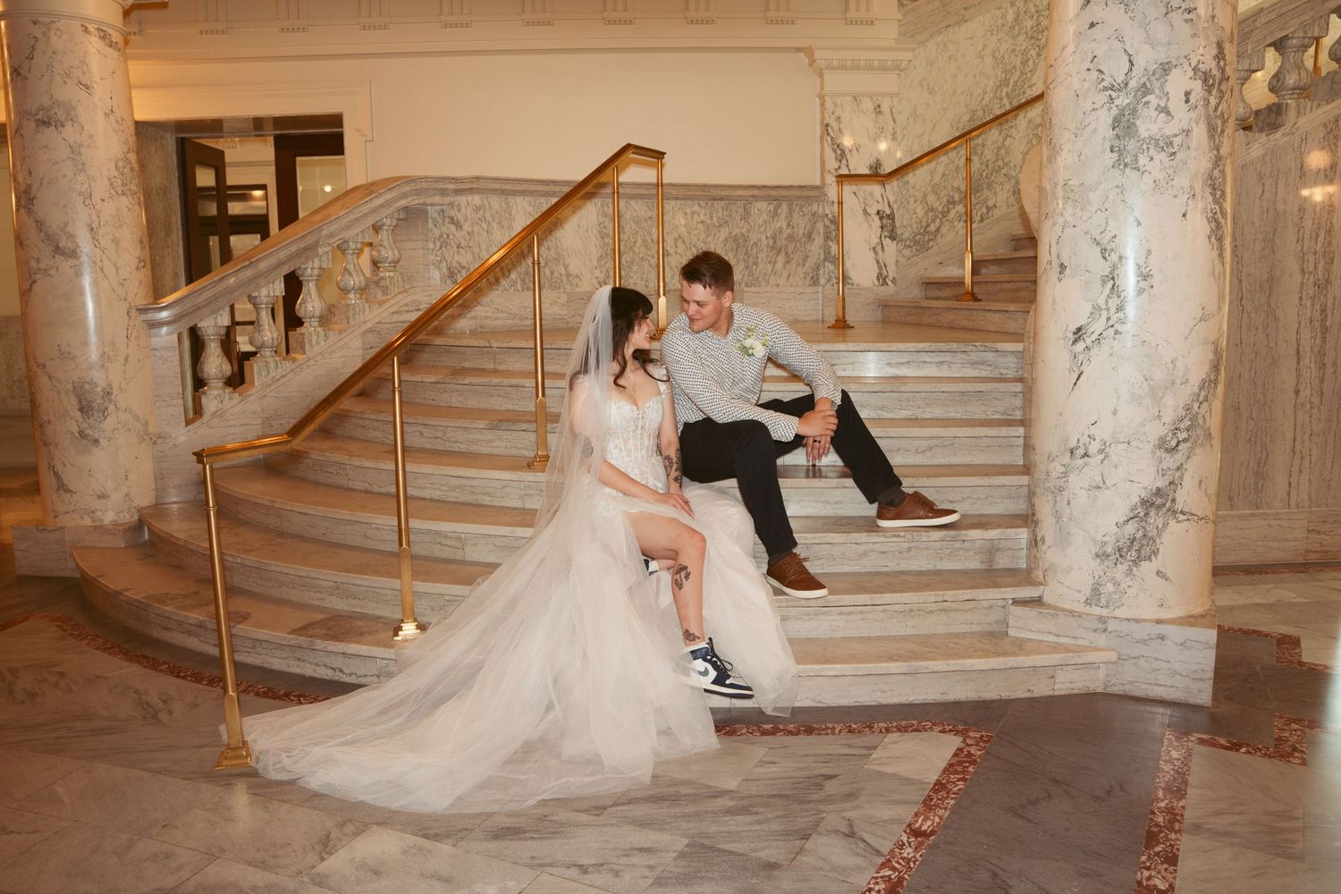 Grand marble staircase in an elegant venue with decorative columns and handrails.