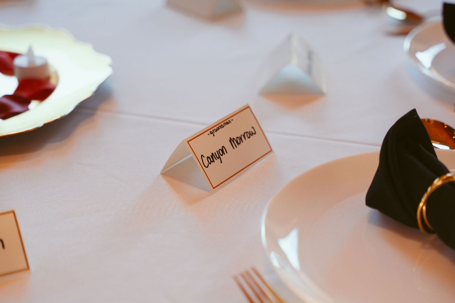 Wedding reception place cards arranged on a white tablecloth.