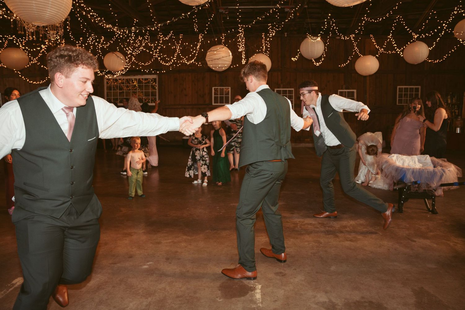 Coordinated group dance routine at a barn wedding reception.