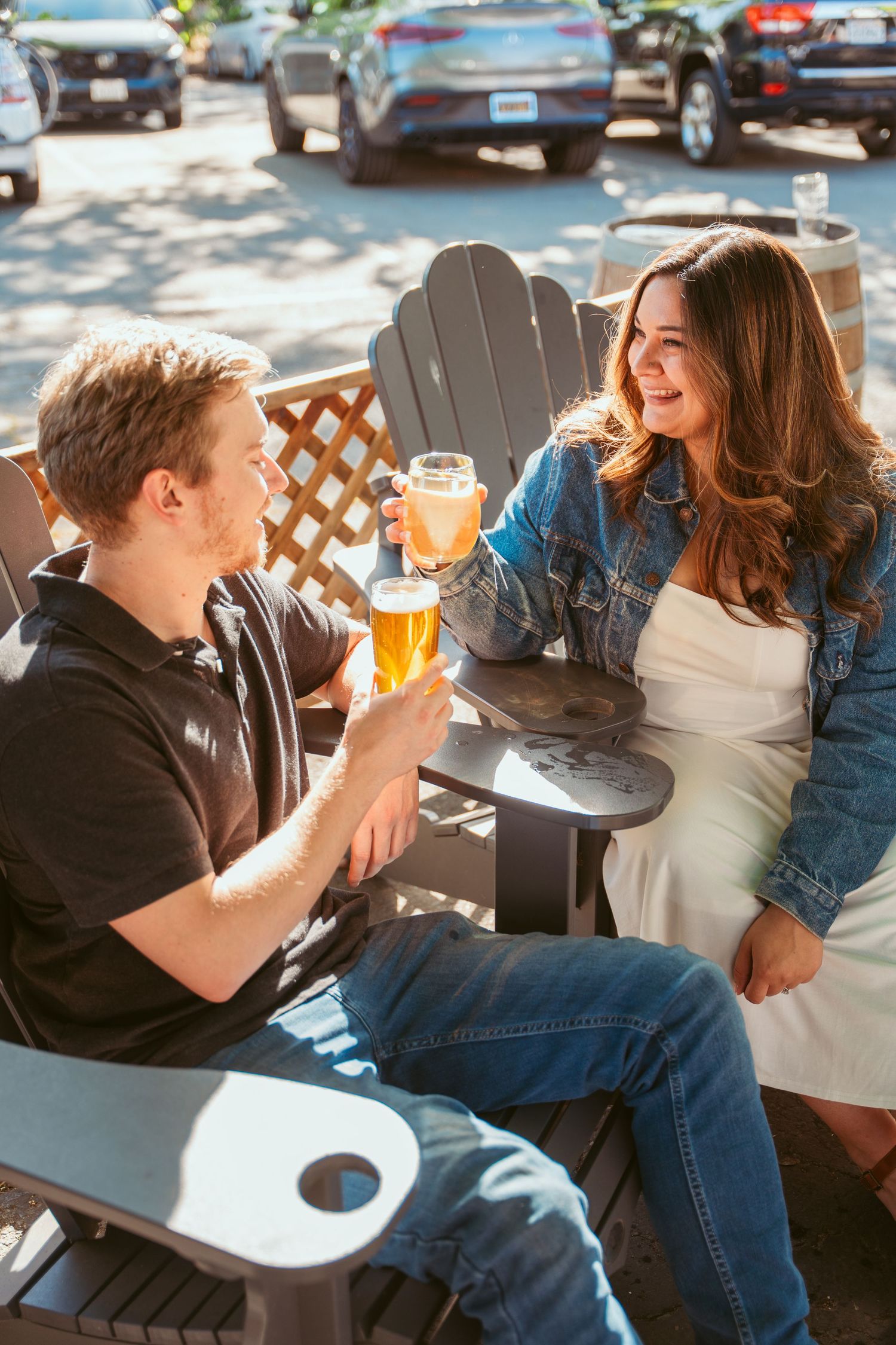 Couple sharing drinks and affectionate moments on outdoor patio seating.