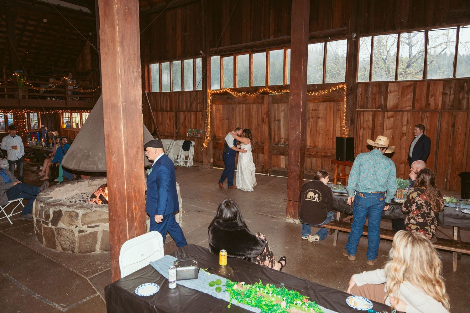 A dance celebration taking place inside a spacious rustic barn venue.