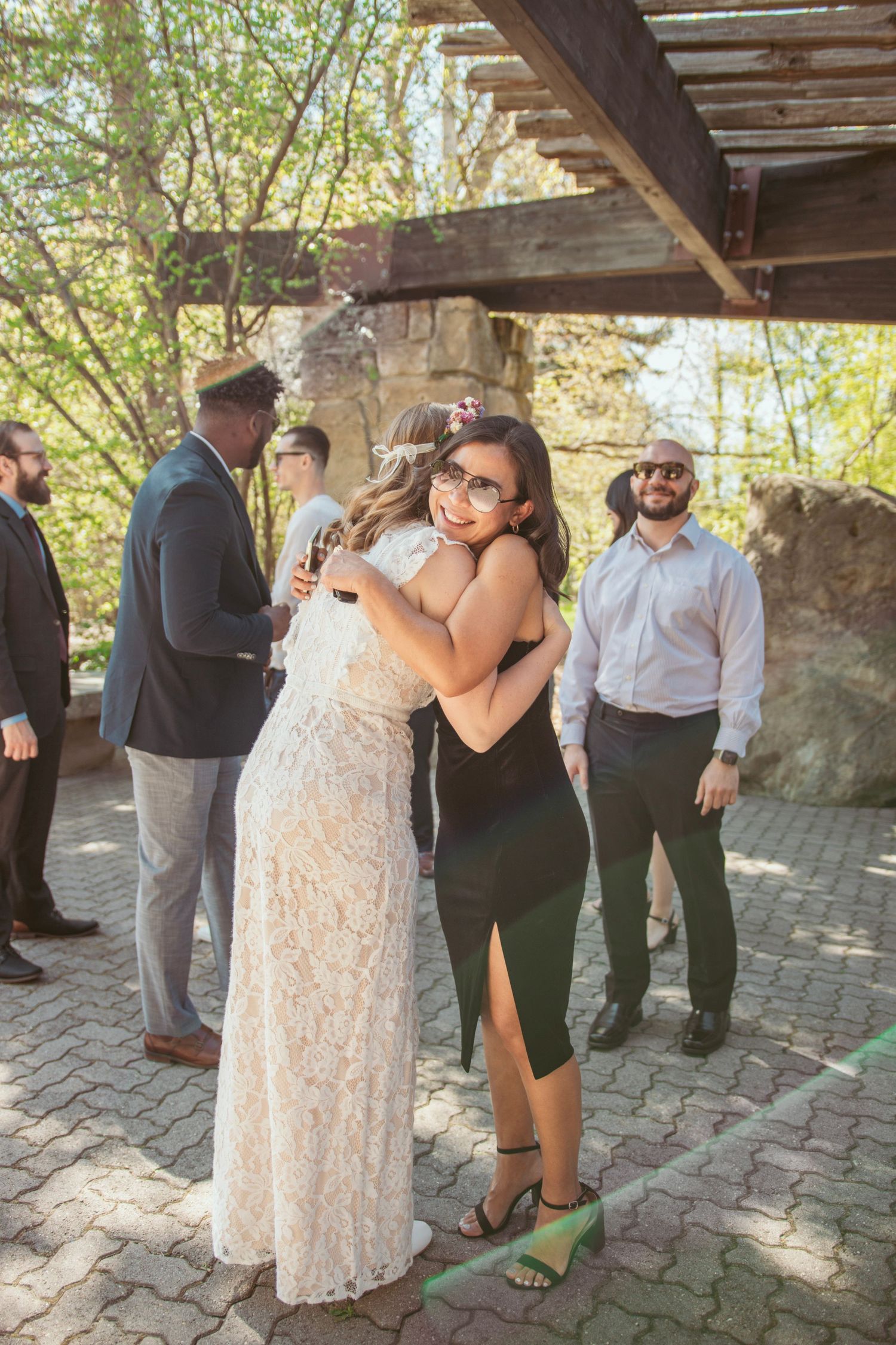 Wedding celebration candid moments captured under a rustic stone pavilion in natural light.