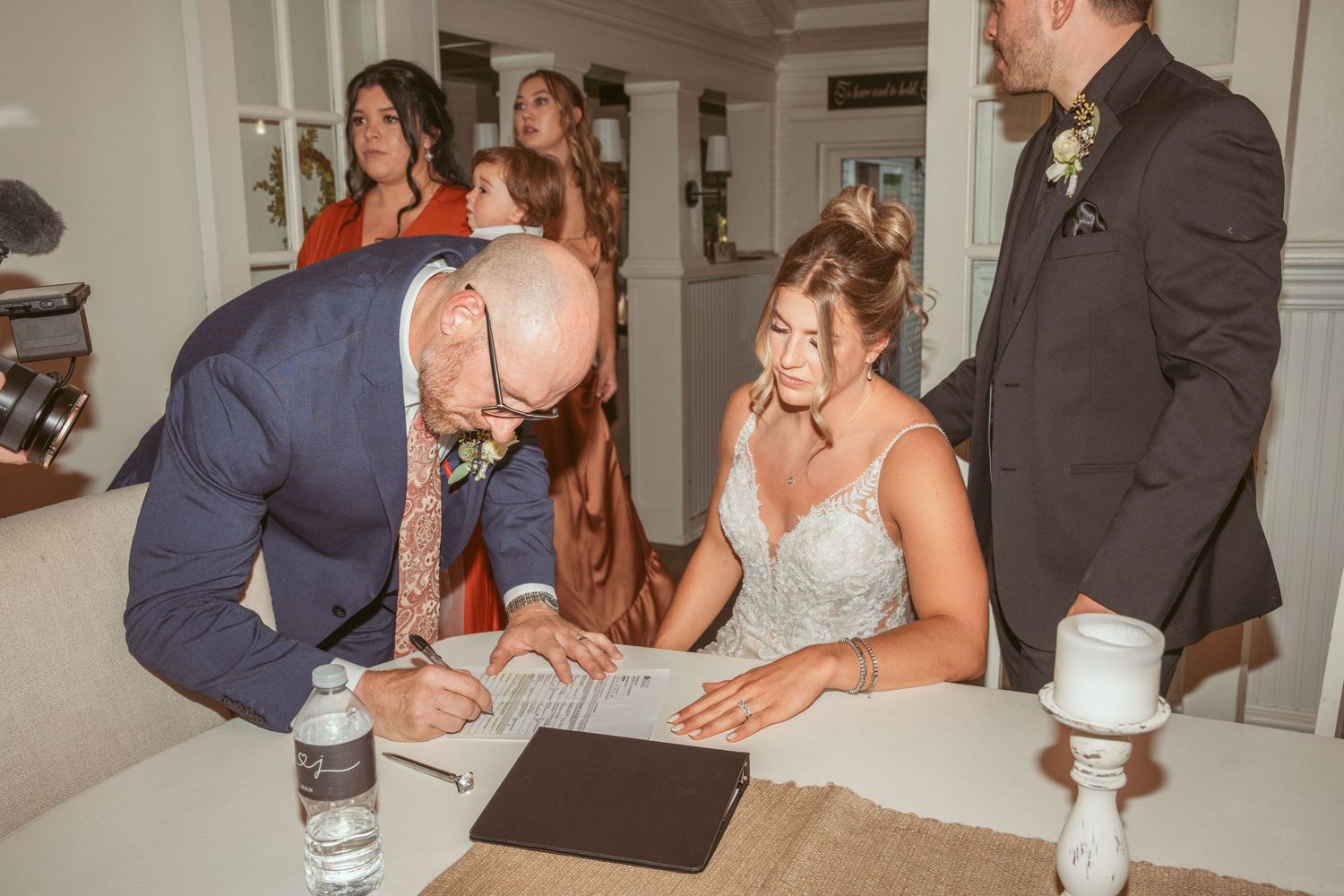 Wedding cake cutting ceremony captured in intimate indoor setting.