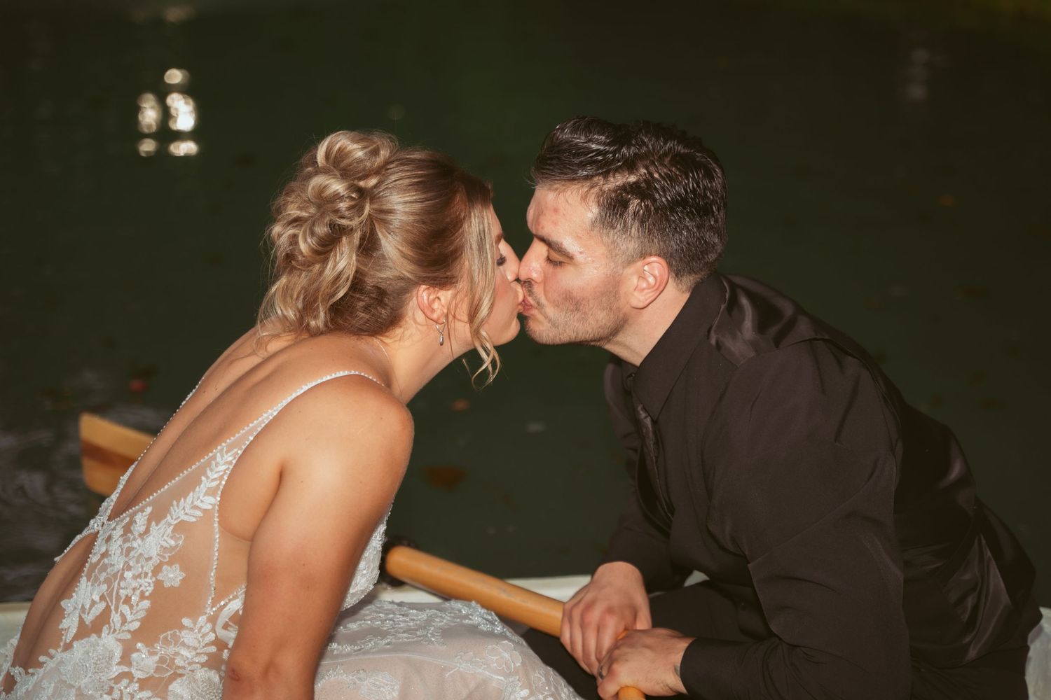 Intimate wedding moment captured in dark, moody lighting.