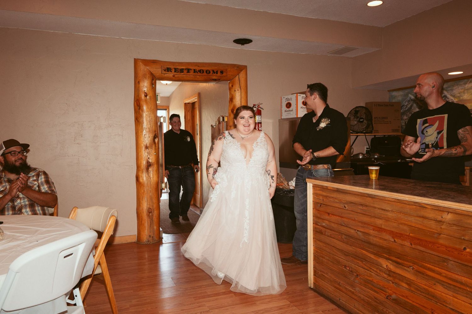 Wedding reception in rustic wooden venue with hardwood floors and warm lighting.