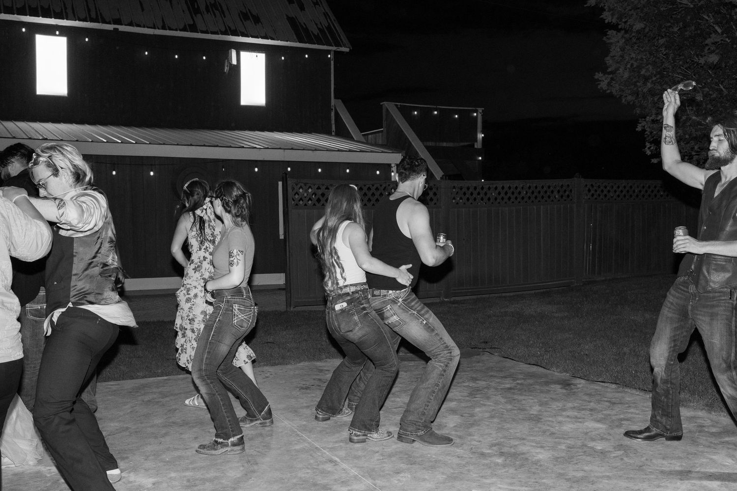 Group of dancers performing choreographed moves on a dark dance floor.