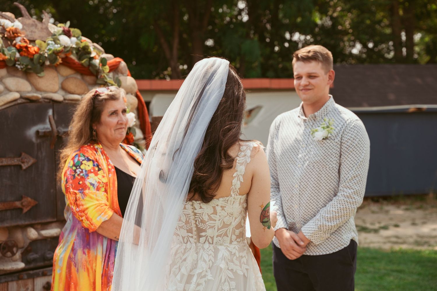 Outdoor wedding ceremony with autumn-themed decorations and natural garden backdrop.