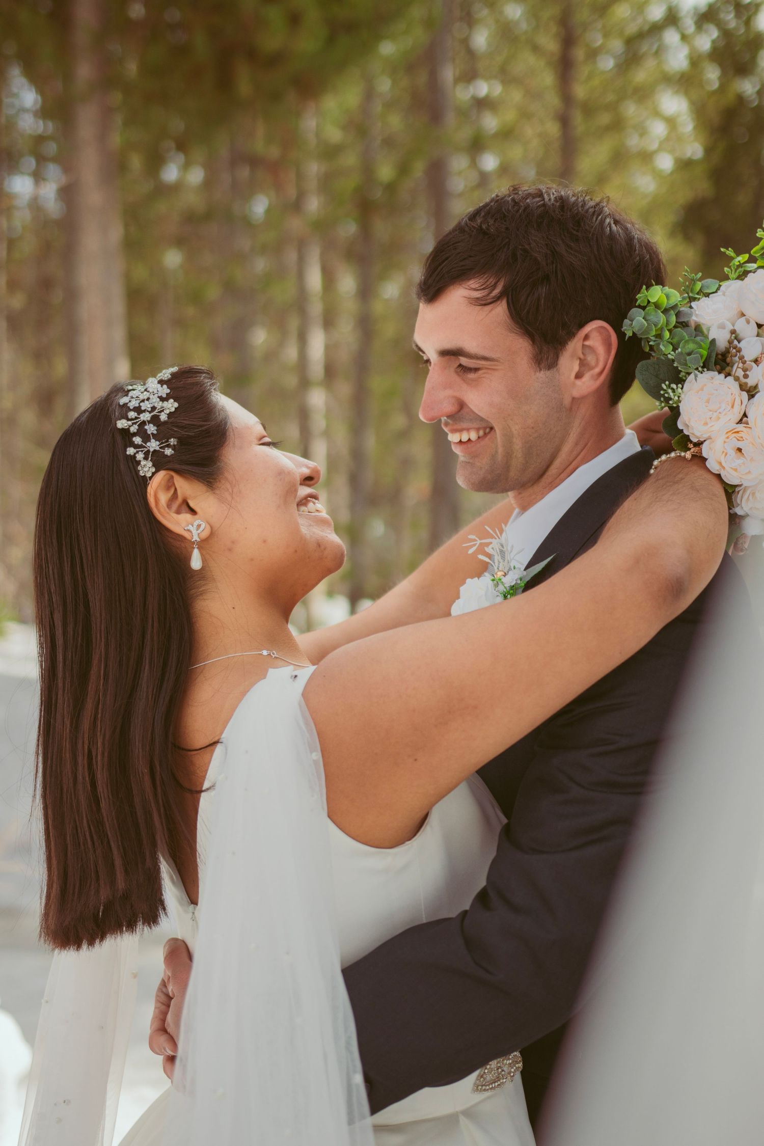 Romantic forest wedding photoshoot with pine trees creating natural backdrop.
