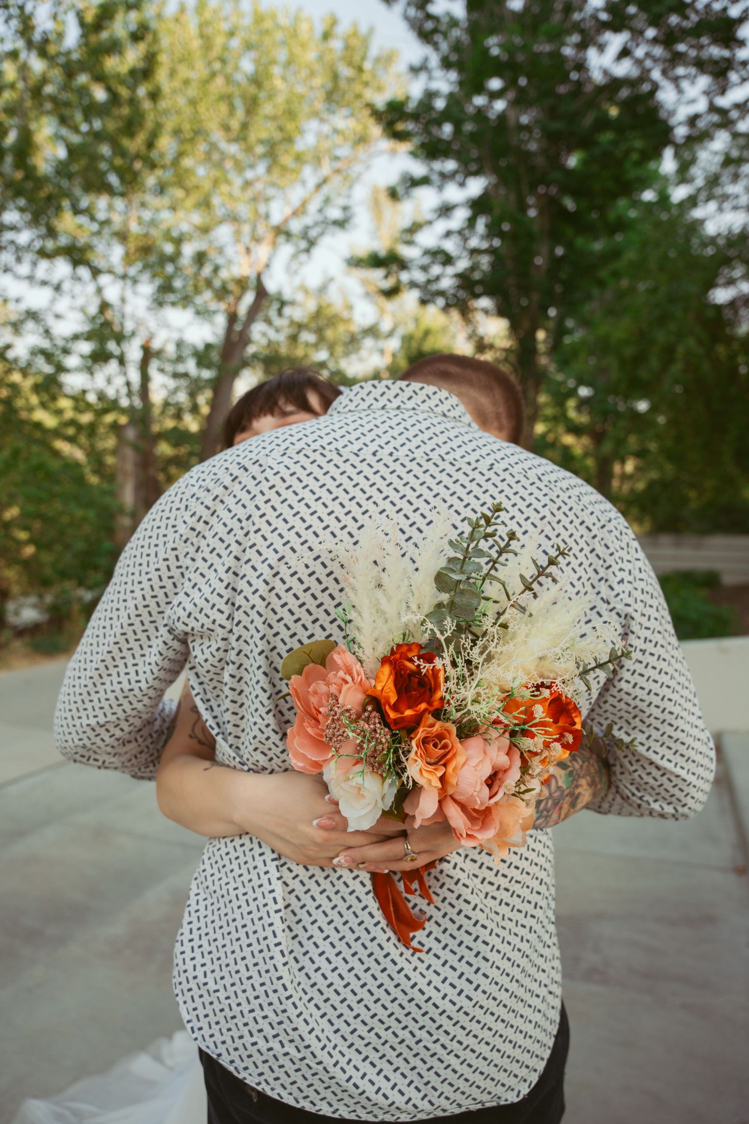 Wedding flowers and greenery arranged artistically across a polka dot shirt.