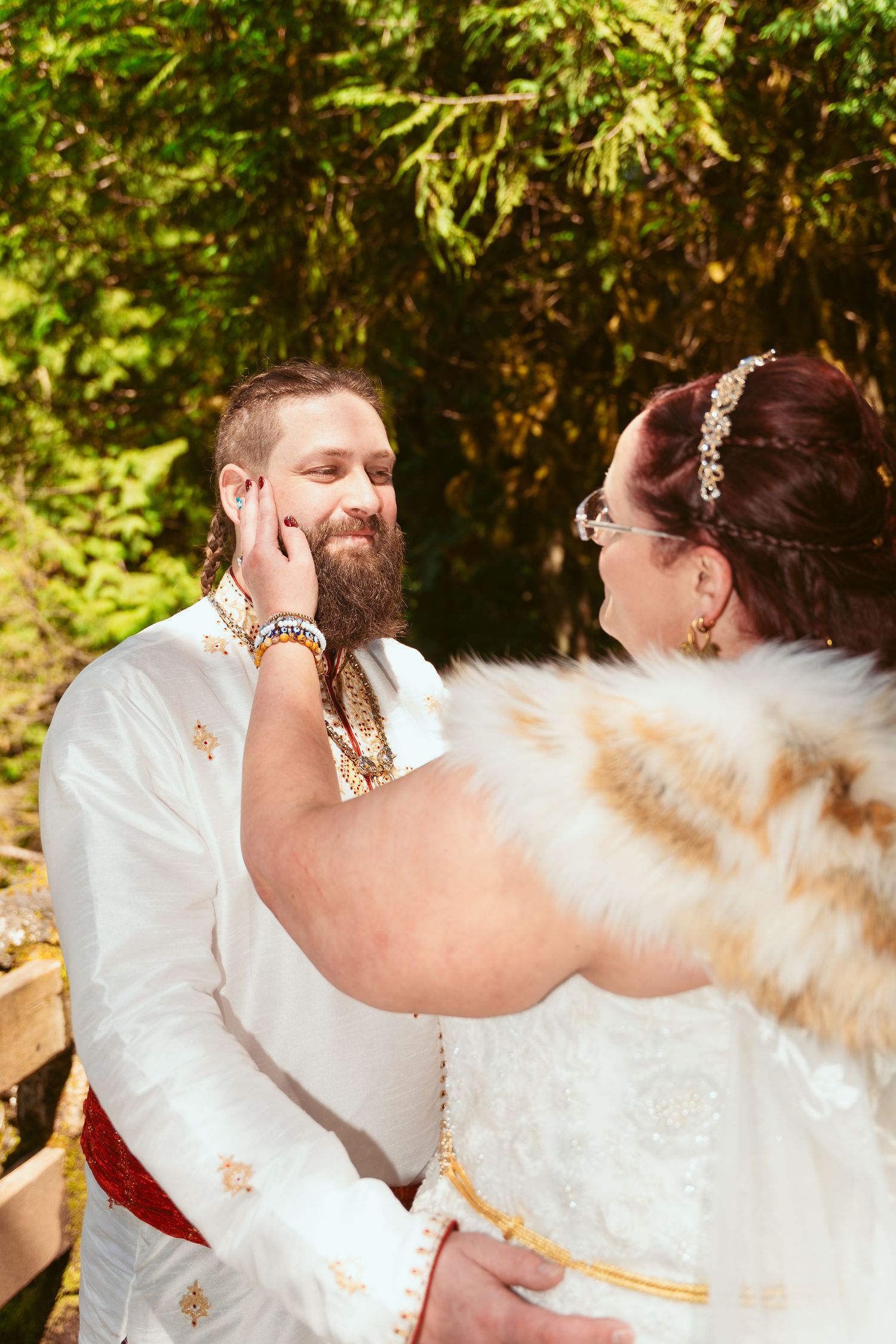 A couple in medieval-inspired wedding attire embraces in a romantic sequence of photos in a forest setting.