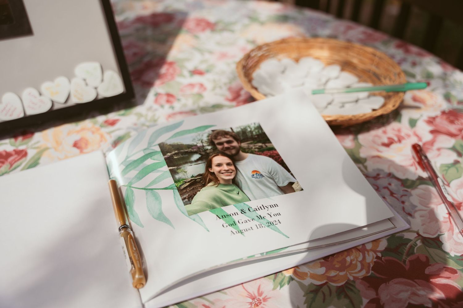 Wedding details and decor items arranged on a floral patterned tablecloth.
