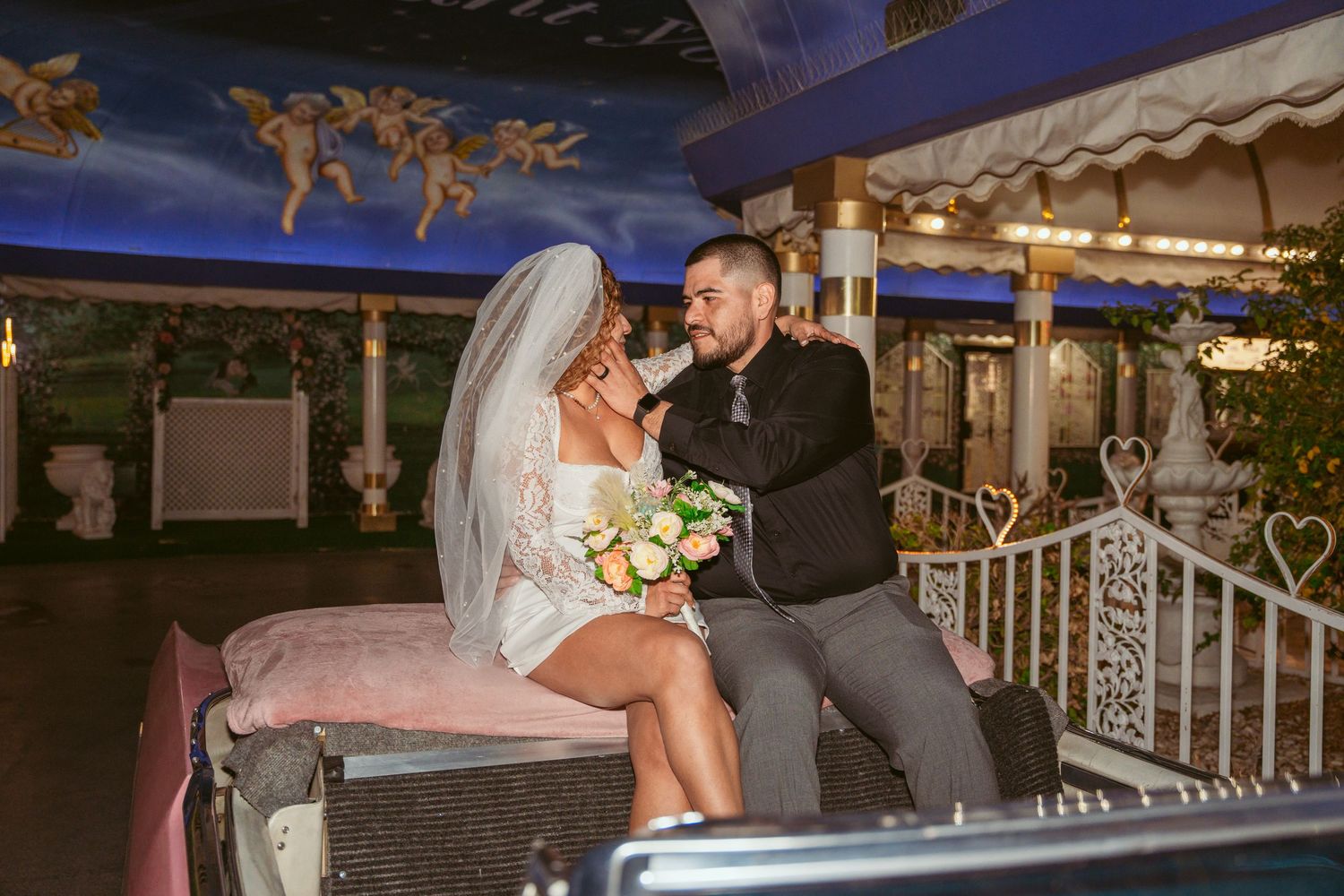 Wedding couple sharing intimate moments near a poolside venue at night.