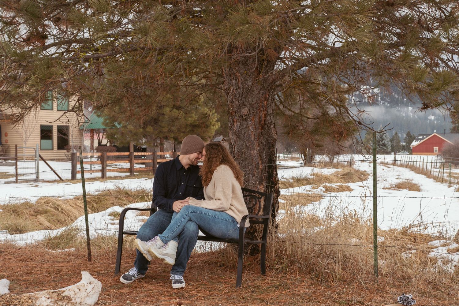 Panoramic winter landscape with couple in distance against snow-covered ground.