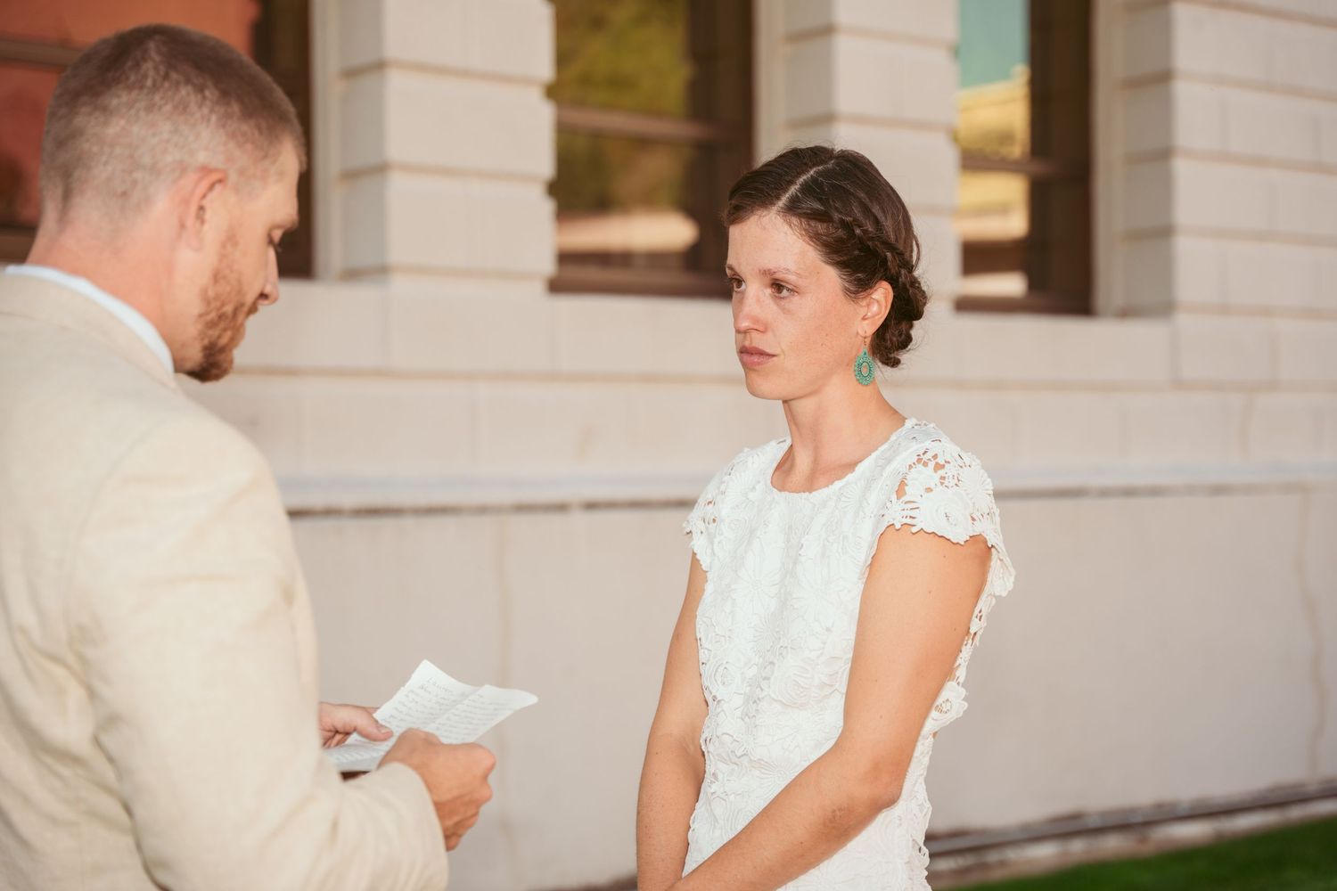 A couple shares written vows during an intimate outdoor wedding ceremony.