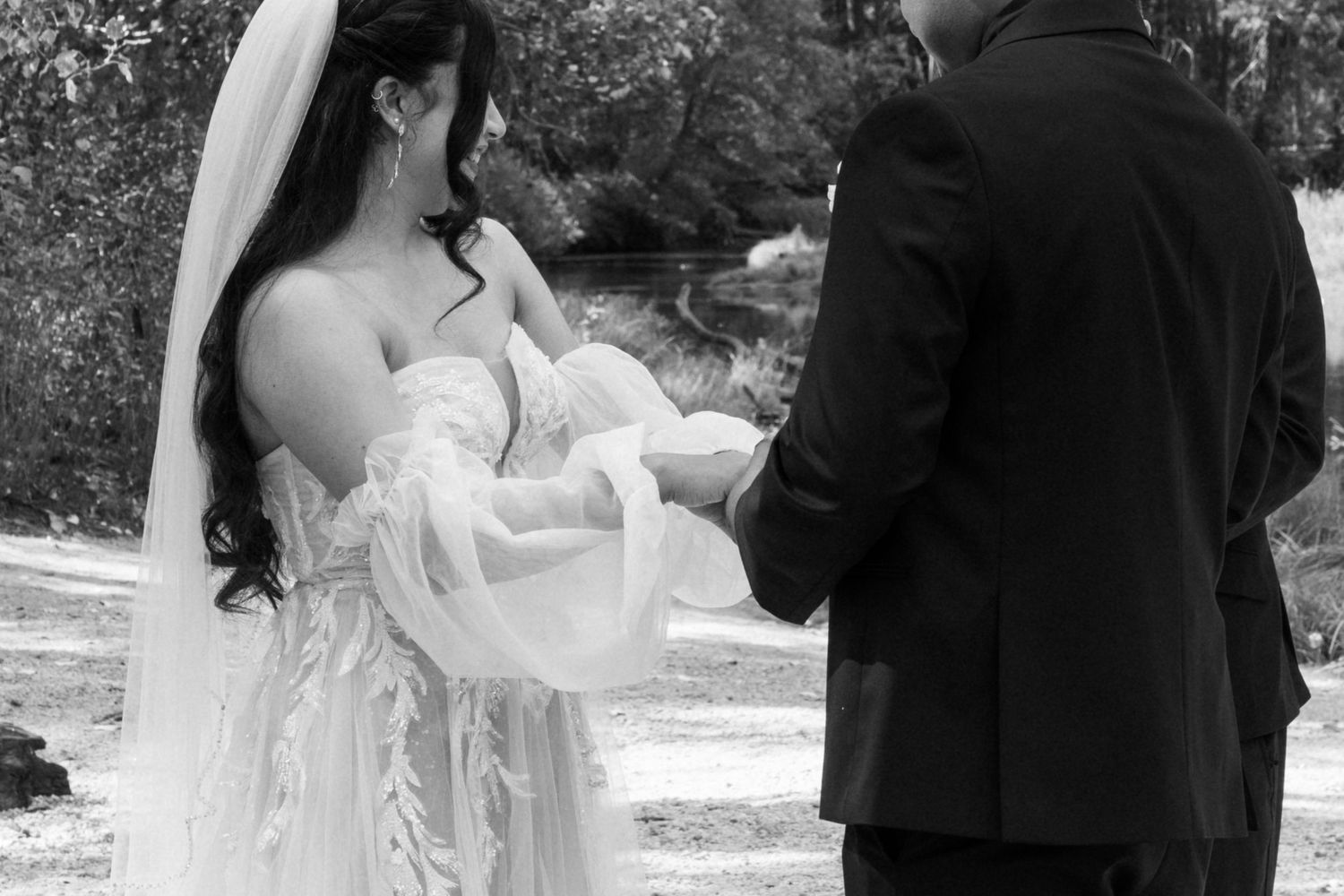 A couple shares an intimate moment during their wedding ceremony in a scenic outdoor setting.