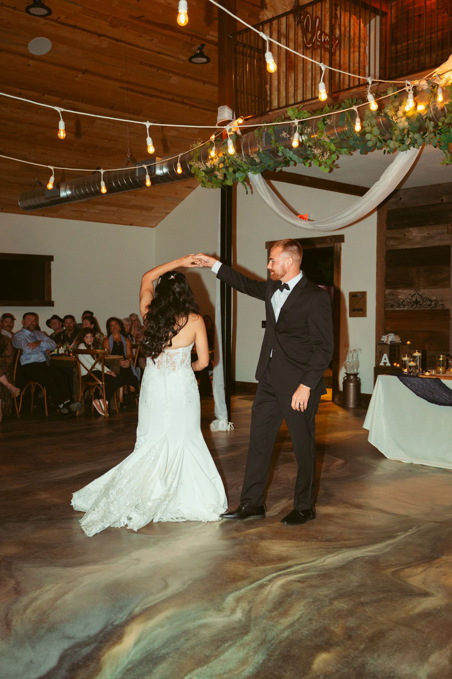 A romantic dance sequence captured during a wedding reception under warm string lights.