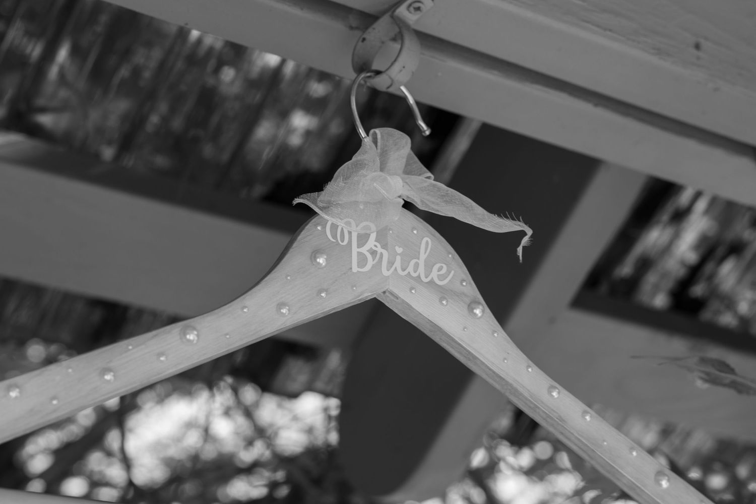 Wedding dress hanger detail with decorative text against light background.