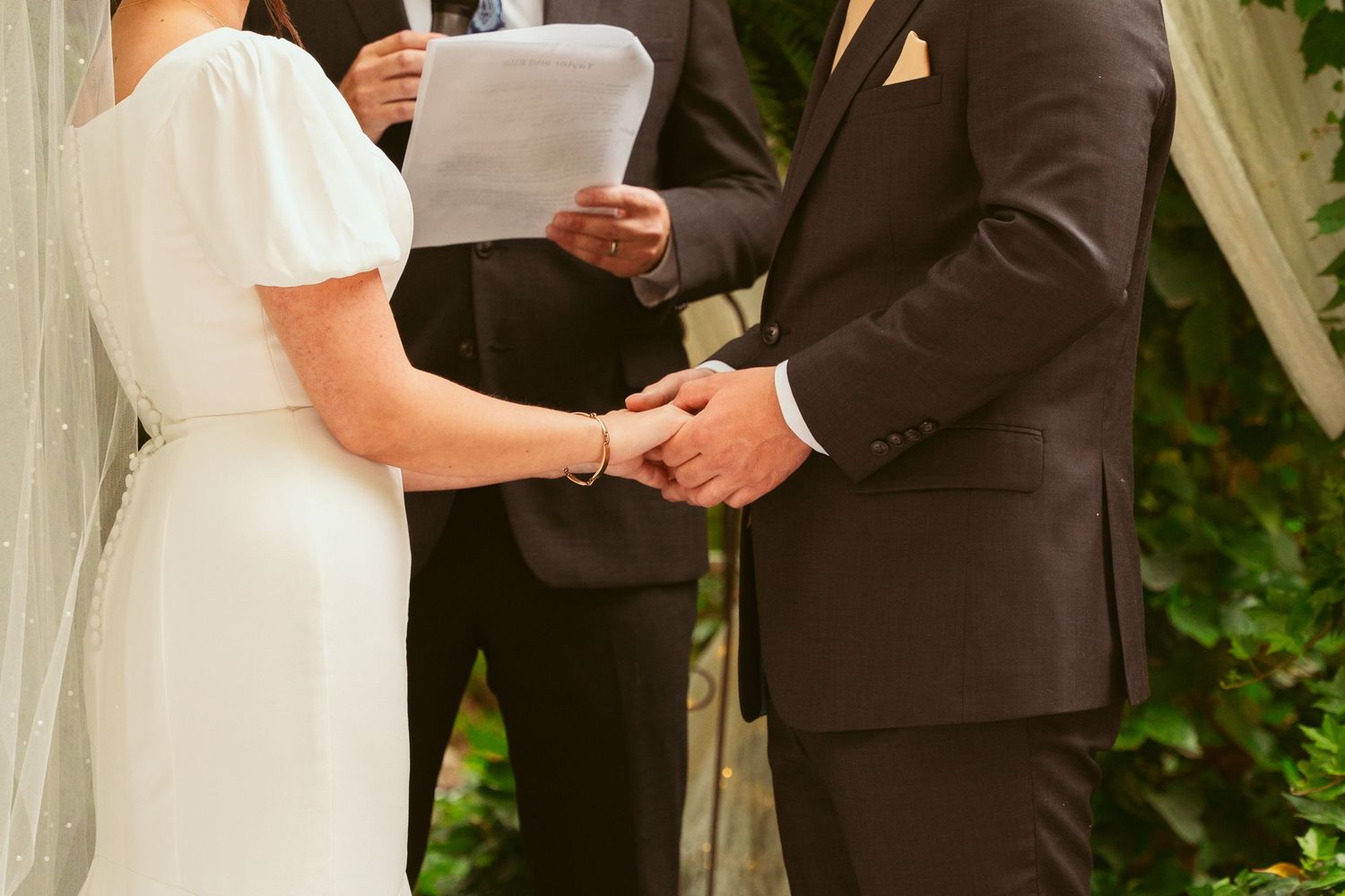 Couple exchanging vows during outdoor garden wedding ceremony.