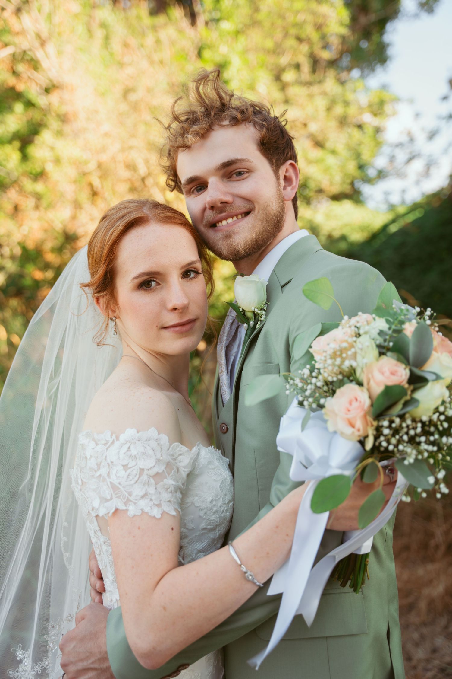 A romantic wedding portrait series featuring a bride in lace and groom in sage green against a sunlit outdoor backdrop.