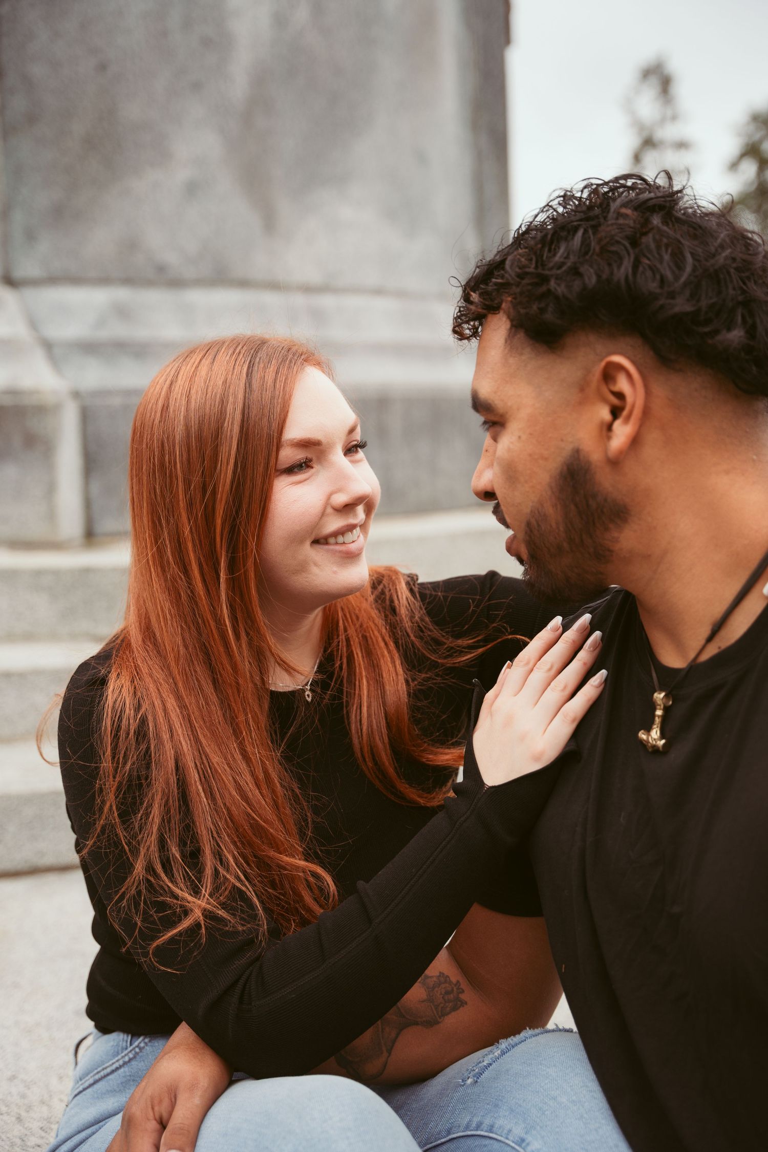 A couple shares candid moments together during a casual outdoor photoshoot.