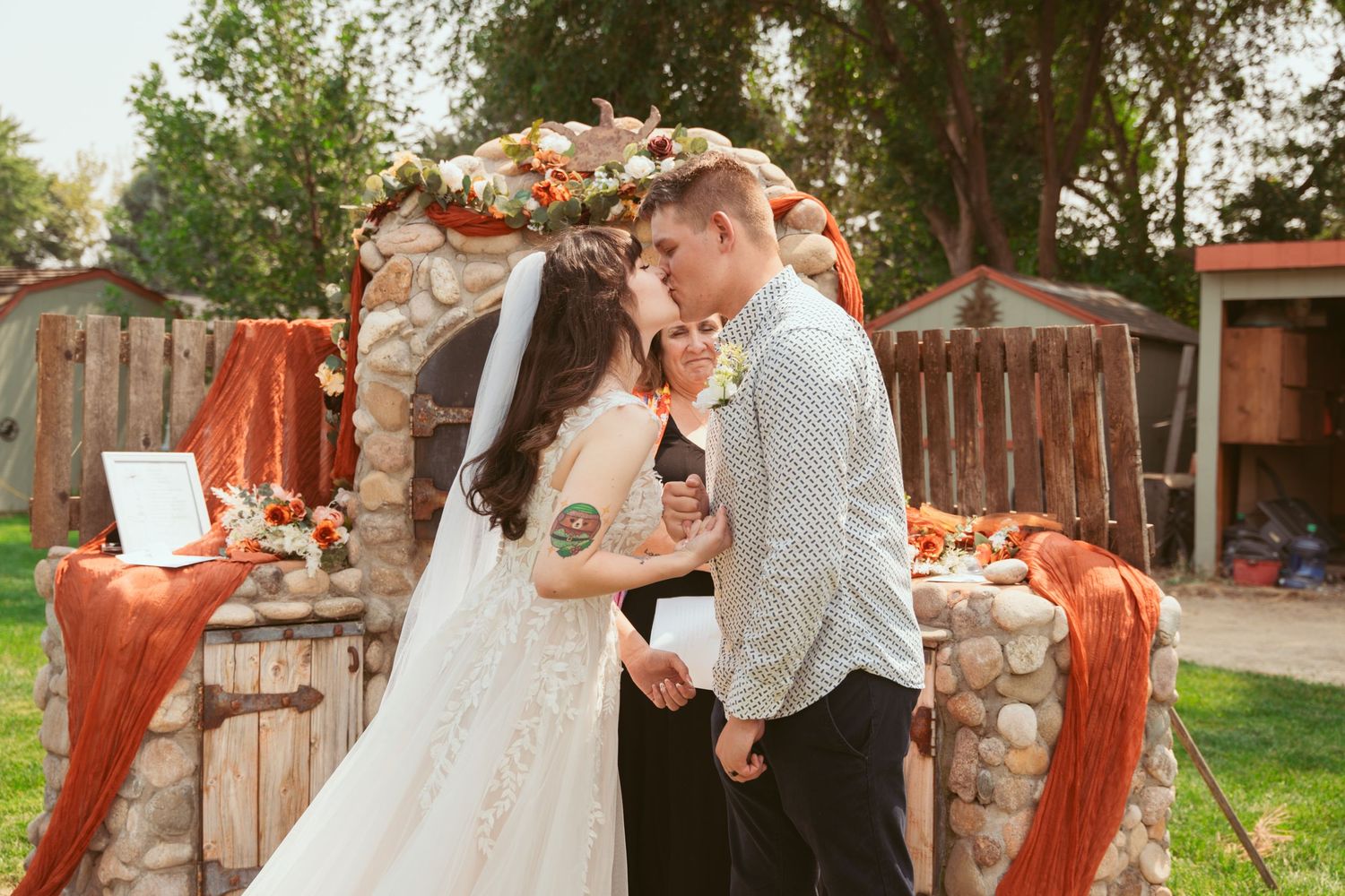 Candid wedding moments captured in an outdoor garden setting with stone features.