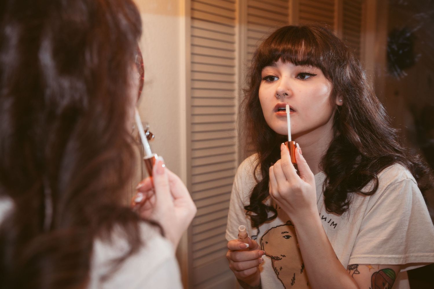 Bride getting ready with makeup application in soft lighting.