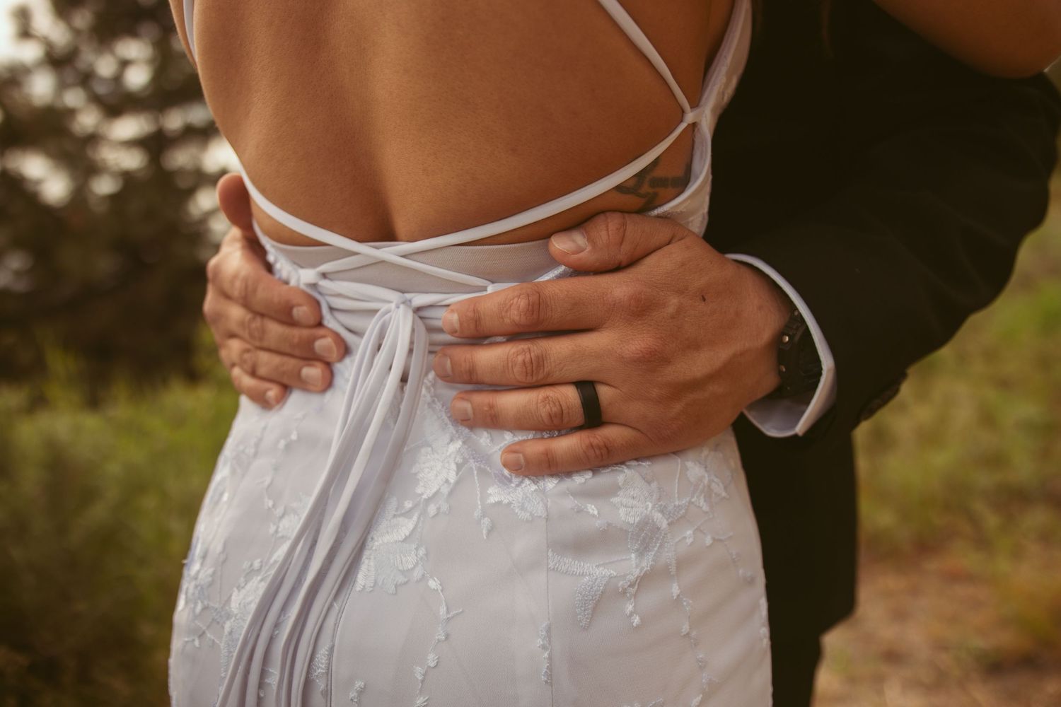 Detail shots of a white corset-style wedding dress back with delicate lacing.