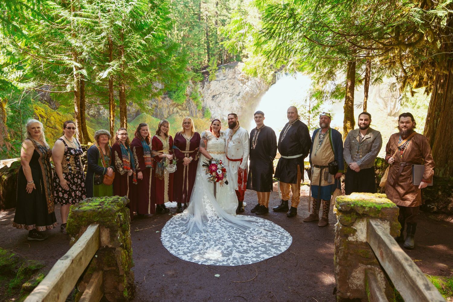 Wide view of wedding guests seated in a forest clearing during an outdoor ceremony.