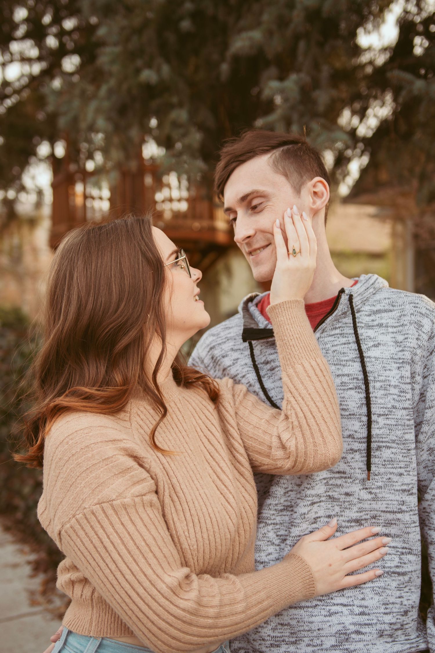 A couple laughing together outdoors while wearing coordinating casual outfits.